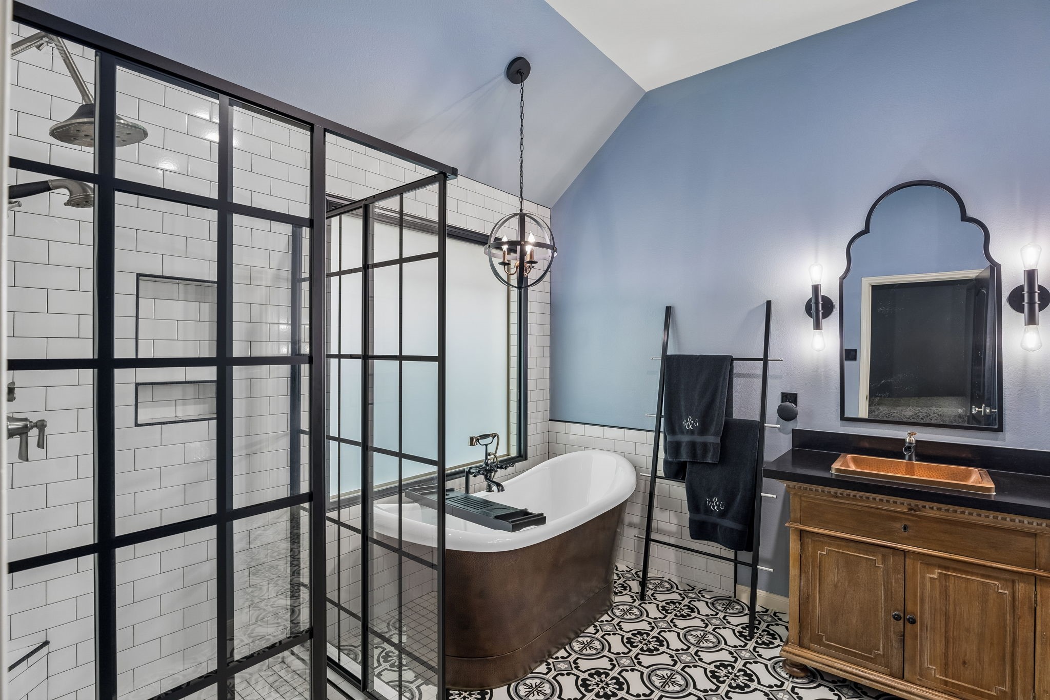 Primary bath with soaking tub, separate glass-enclosed shower, and dual-sink vanity.