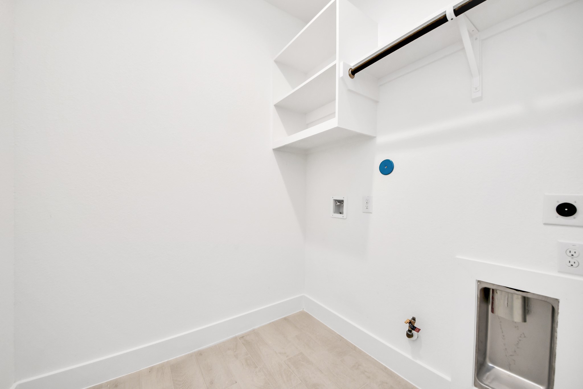 A perfect blend of functionality and comfort. Capture the essence of easy living with a first-floor laundry room, thoughtfully equipped with shelving for effortless organization. Both electric and gas connections available. Sample photo of completed home with similar floor plan. Actual colors and selections may vary.