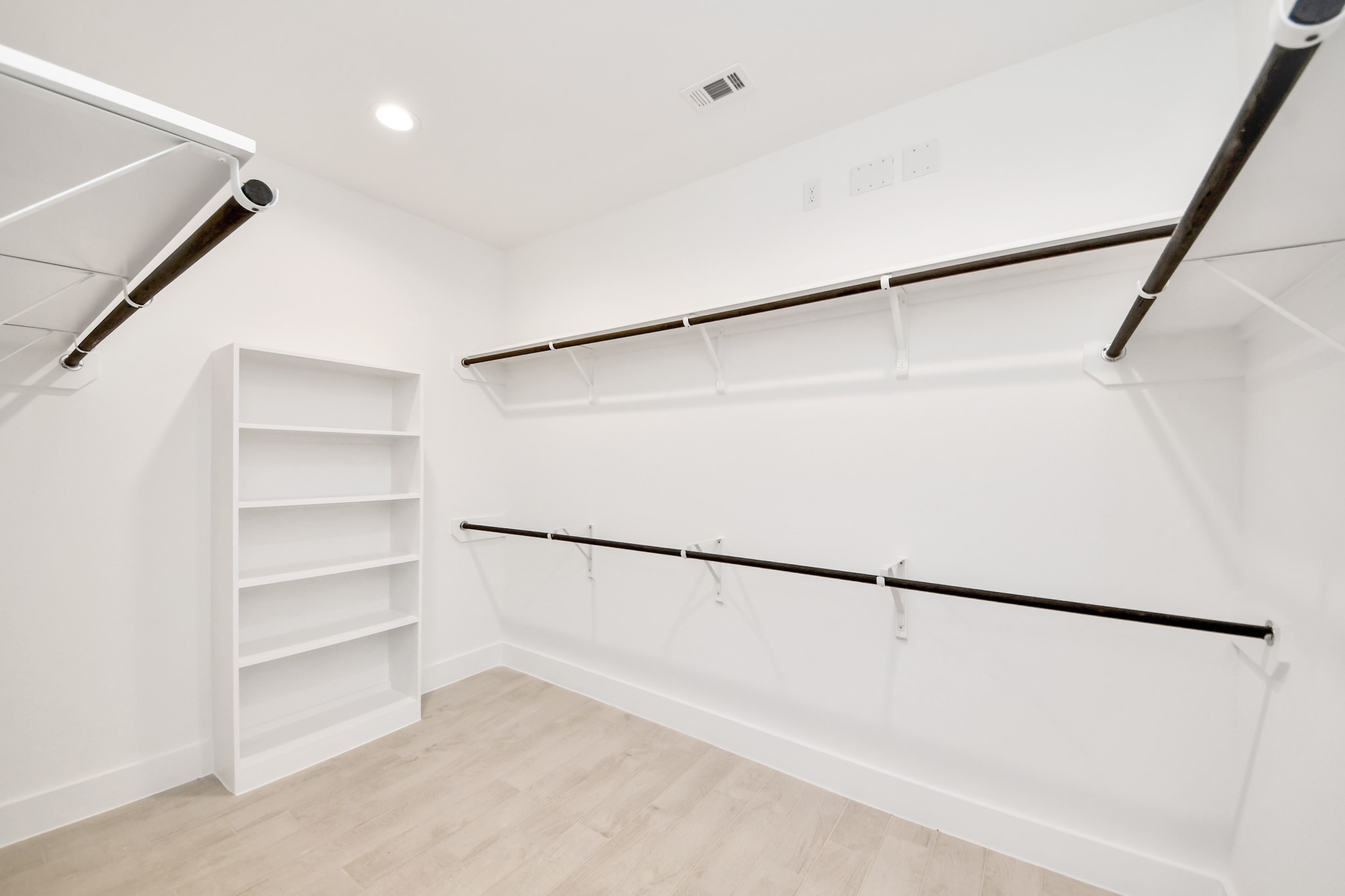 Walk-in closet that epitomizes luxury and practicality. This generously sized space features built-in shelving, offering abundant room for impeccable organization. High ceilings and recessed lighting create a bright and welcoming ambiance. Sample photo of completed home with similar floor plan. Actual colors and selections may vary.