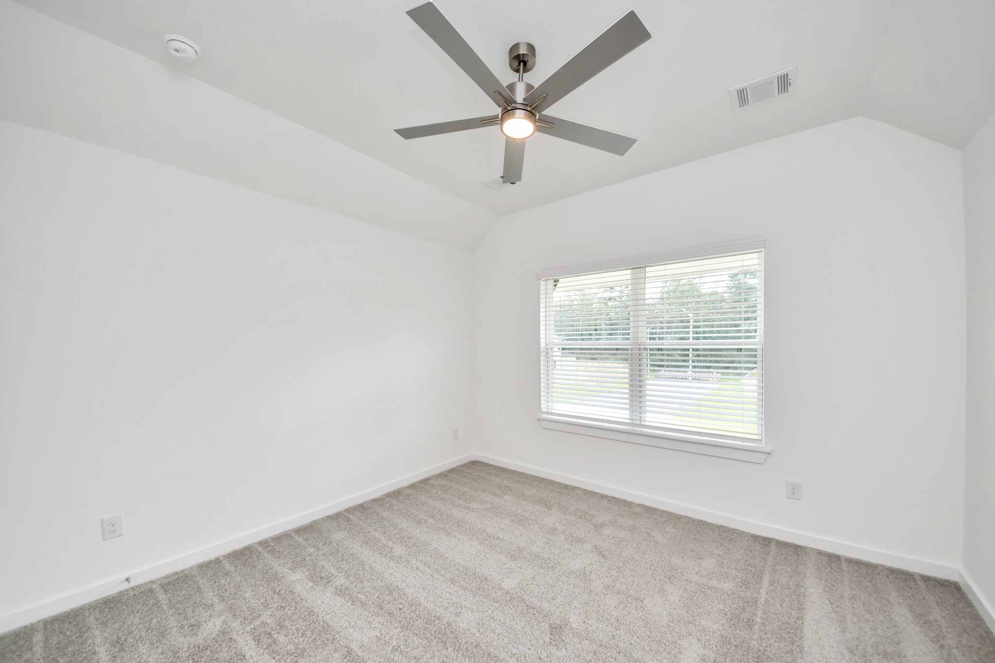 Secondary bedroom features plush carpeting, large windows that let in plenty of natural light, bright paint, and spacious closets. Sample photo of completed home with similar floor plan. Actual colors and selections may vary.