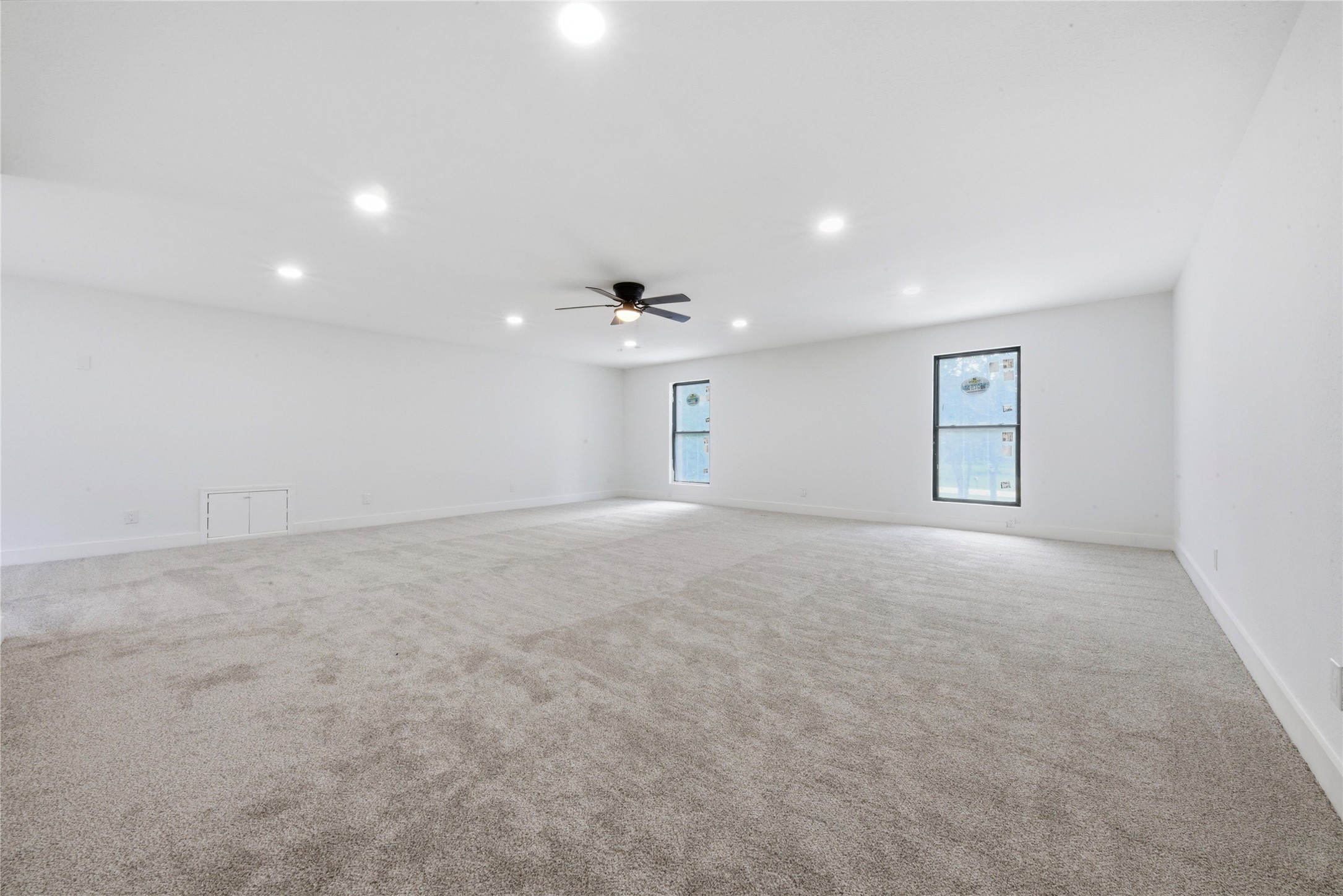 Expansive upper-level suite above the detached garage. Approximately 723 SF of carpeted, climate-controlled flex space with vaulted ceilings, ceiling fan, recessed lighting, and oversized windows. Ideal for guest quarters, home office, gym, studio, or rental potential.