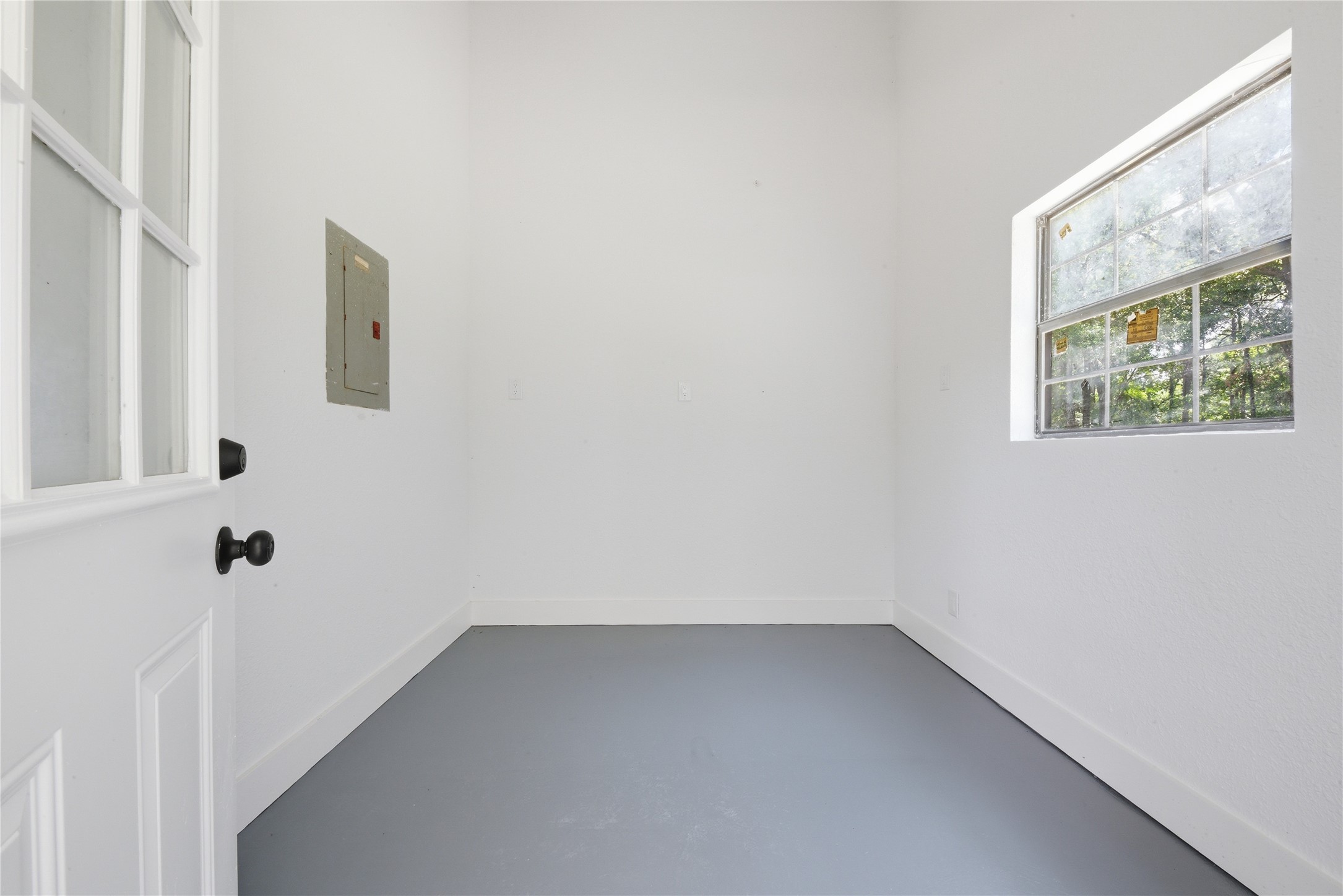 Sub-panel and utility room within the detached structure offering additional functional storage, mudroom, or workshop space with natural light.