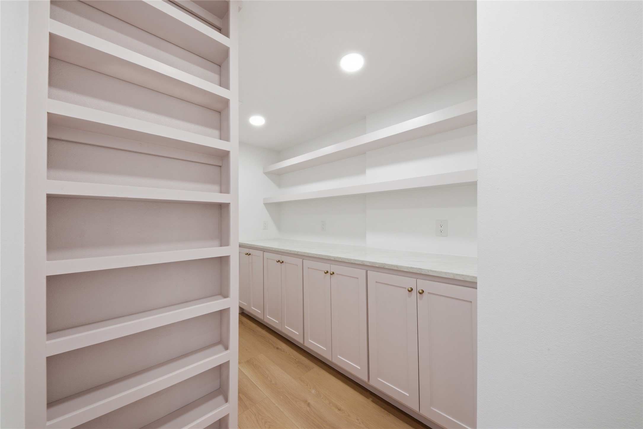 Oversized walk-in pantry featuring floor-to-ceiling custom shelving, soft-close lower cabinetry, quartz counter prep space, and recessed lighting. A rare luxury for serious cooks and entertainers.