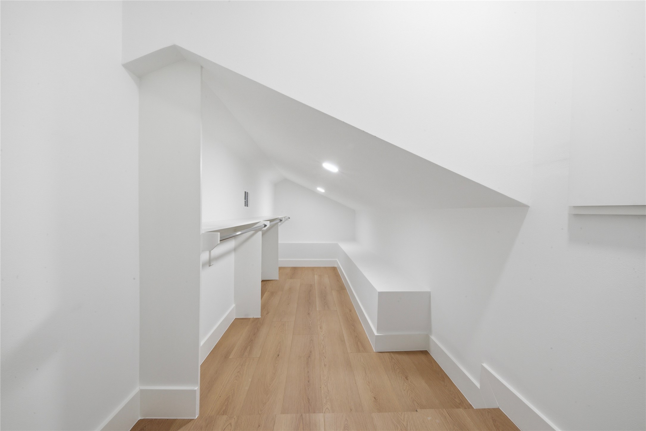 Finished closet/storage area accessed from the third floor. Wide-plank floors, recessed lighting, and built-in clothing rod offer additional functional space, ideal for closet, seasonal storage or wardrobe overflow.