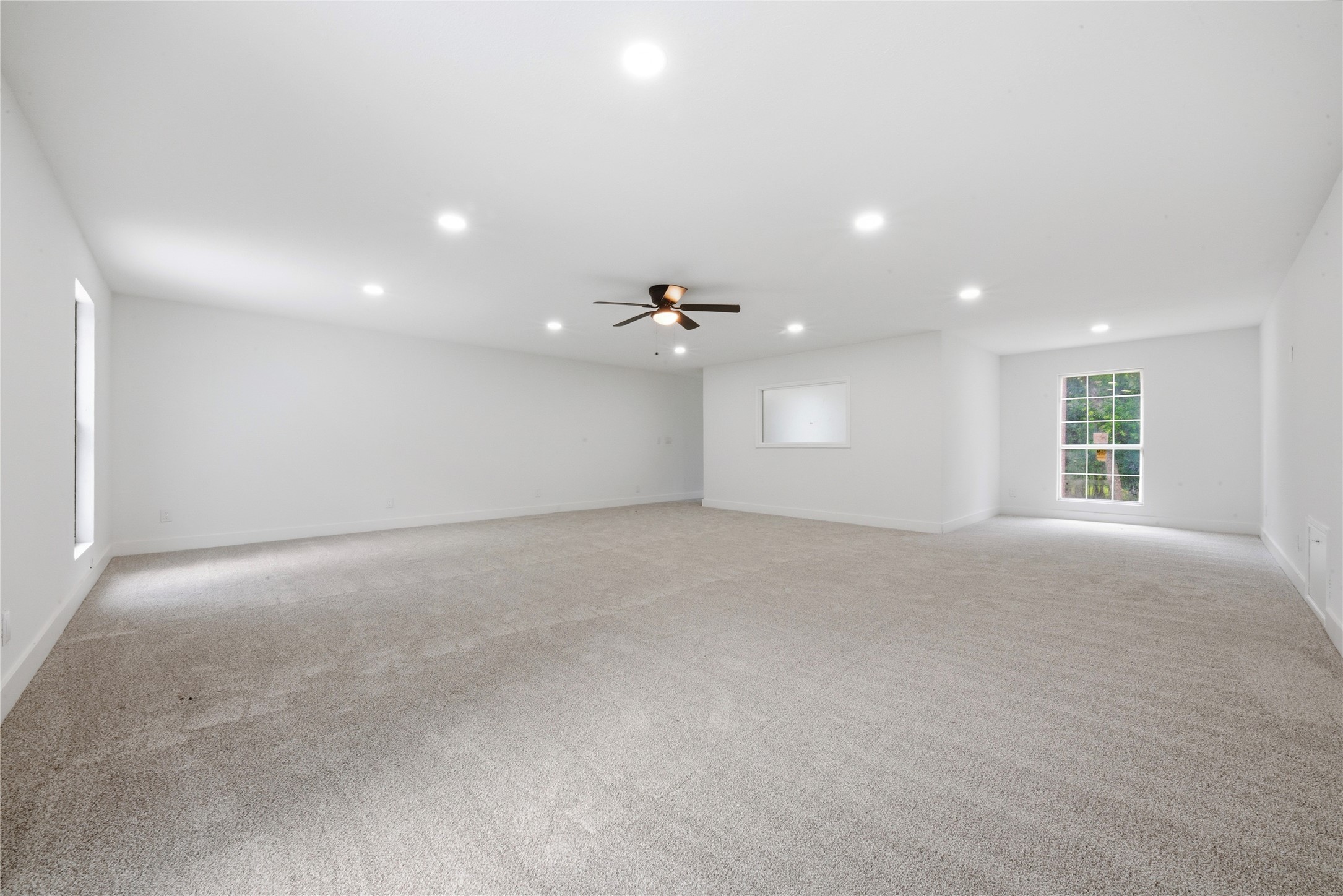 Second view of the upper-floor detached suite showing the impressive scale, multiple windows for natural light, and white grid-pattern accent window. Endless possibilities, private retreat, in-law suite, podcast studio, or income-producing space.