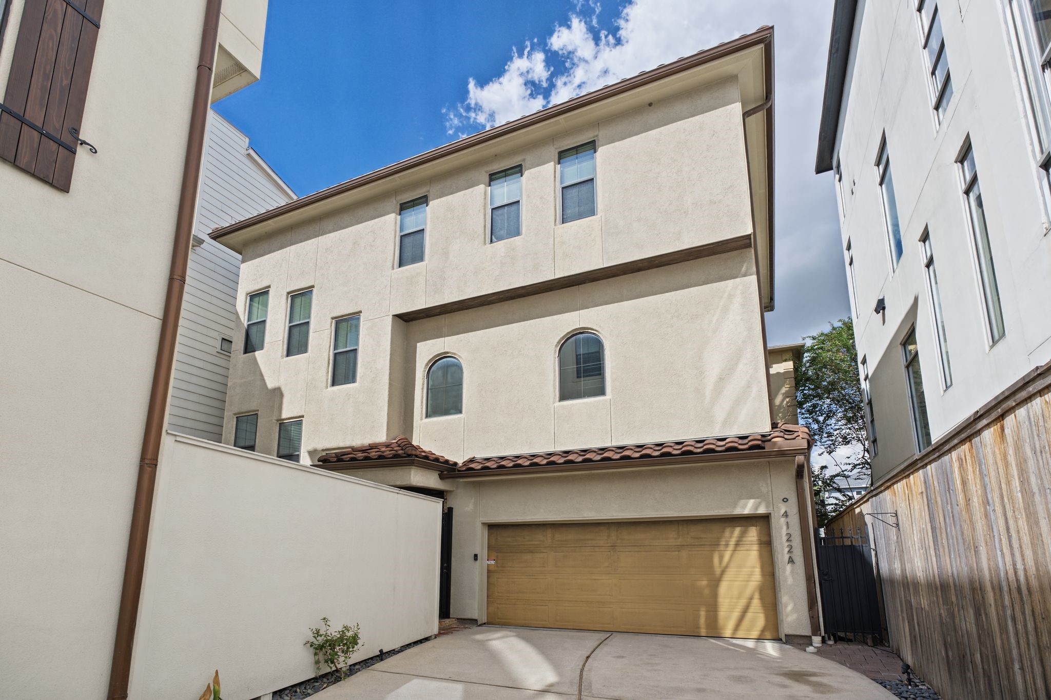 Exterior | Private Gated Enclave  Tucked beyond a motorized gate, this Mediterranean-inspired residence enjoys a discreet setting within an intimate enclave of just two homes, where a shared driveway offers a welcoming sense of privacy and seclusion in the heart of Rice Military.