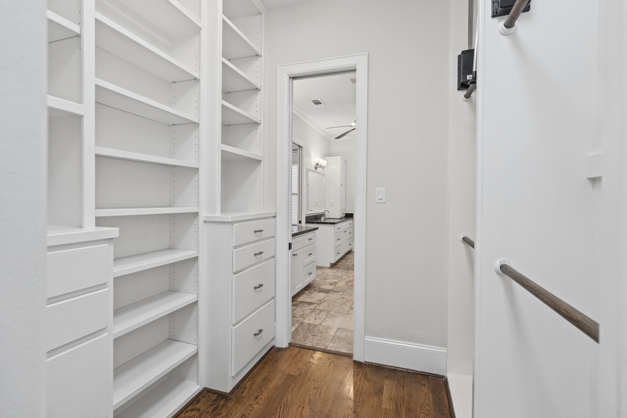 Primary Walk-In Closet  Third Floor. Beautifully appointed with floor-to-ceiling custom built-ins, this spacious dressing room offers thoughtfully organized storage and a boutique-inspired setting for the everyday ritual of getting ready.
