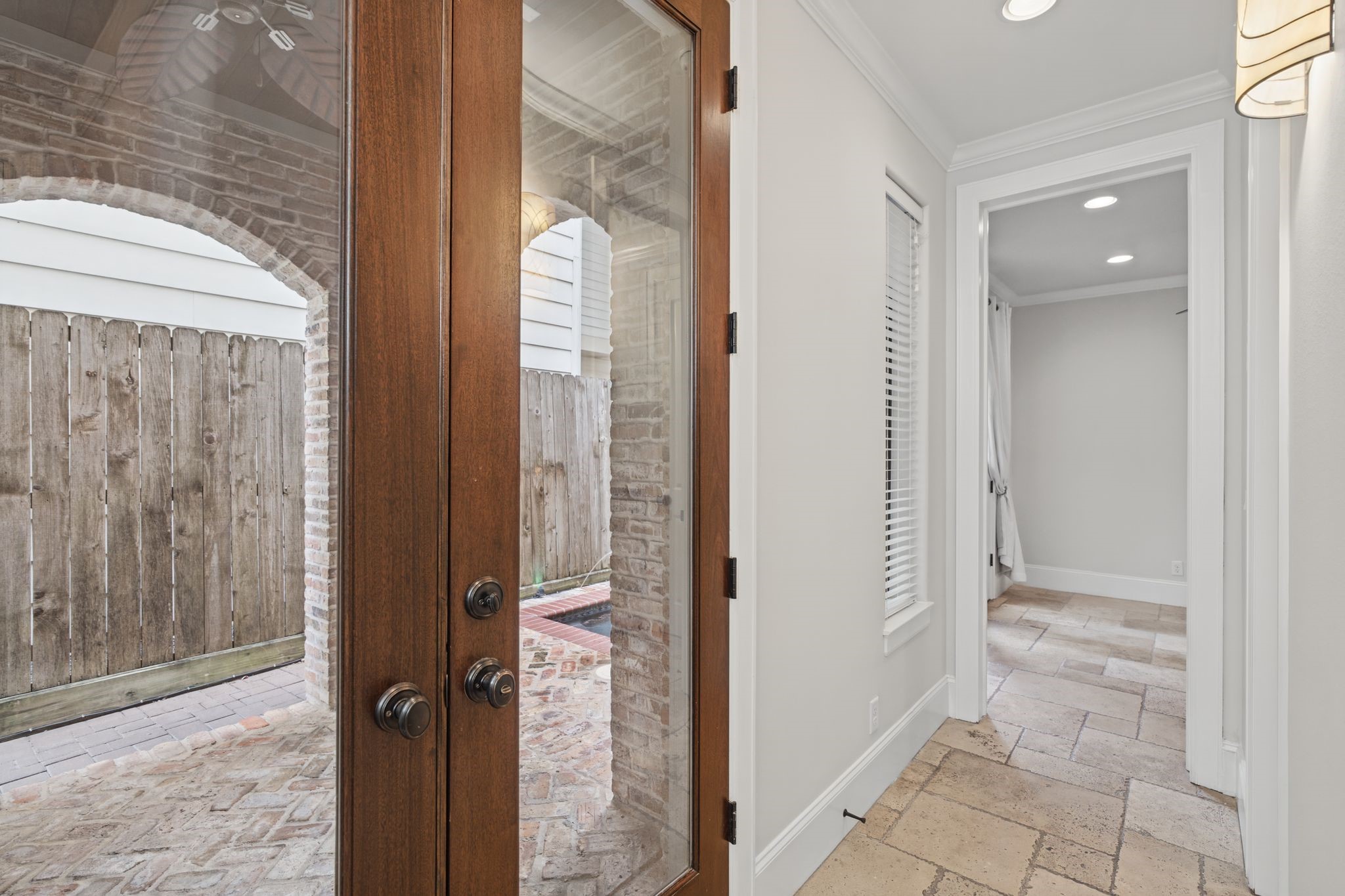 Foyer | French Doors  First Floor  Elegant, clear-glass French doors invite natural light into the foyer while offering a beautiful transition to the summer kitchen, where indoor comfort gives way to the pleasures of outdoor living.