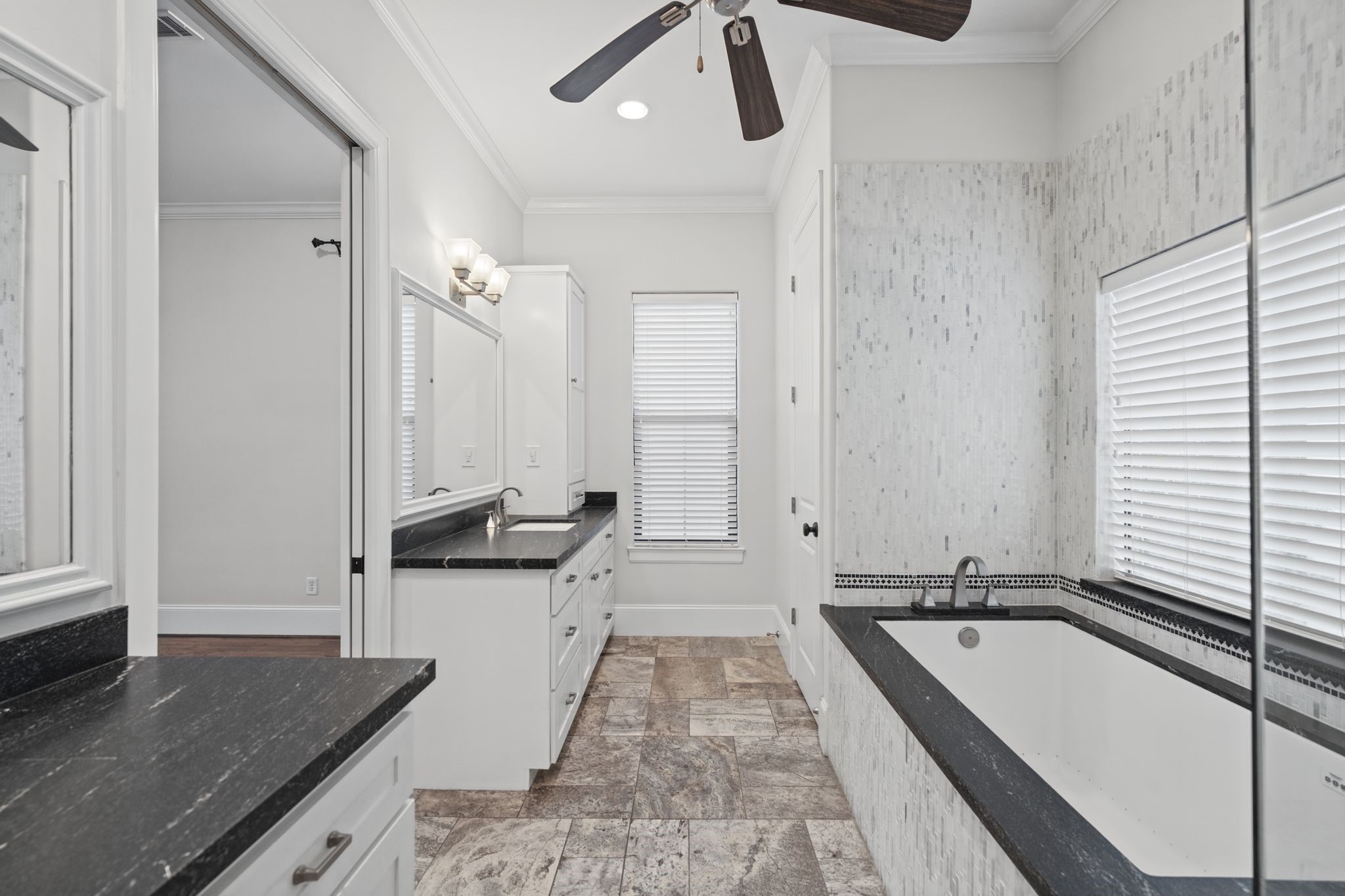 Primary Bathroom [9 x 16]  Third Floor. An intimate spa-inspired escape featuring a relaxing jetted soaking tub, separate glass-enclosed shower, and two individual vanity areas with shaker-style cabinetry. A thoughtful balance of everyday functionality and restorative comfort.