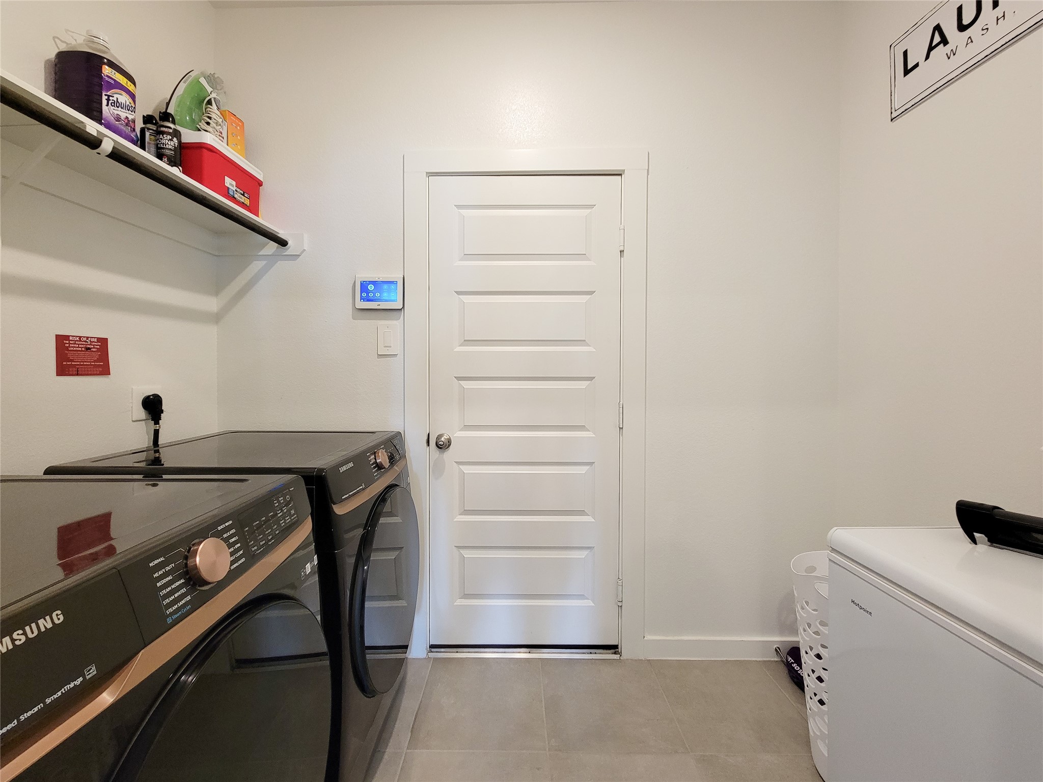 Modern laundry room featuring sleek appliances, ample shelving, and a convenient layout for efficient organization.