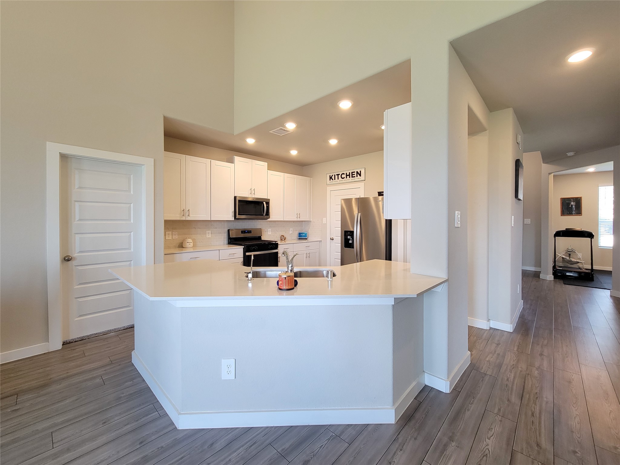 Modern kitchen with sleek stainless steel appliances, white cabinetry, and a spacious peninsula countertop, perfect for cooking and entertaining.