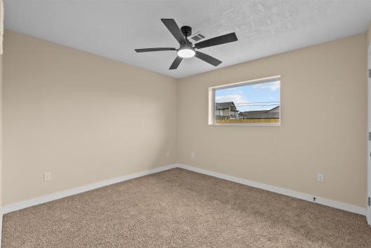 Bedroom #3 with new carpets, ceiling fans, and large windows for natural light.