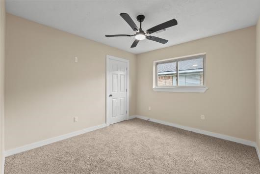 bedroom #2 with new carpets, windows, and ceiling fans