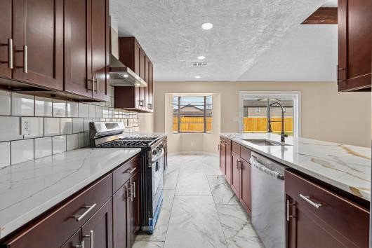 This spacious kitchen features a stylish, modern backsplash, large windows allowing much natural light. This spacious kitchen features a stylish, modern backsplash, large windows allowing much natural light.