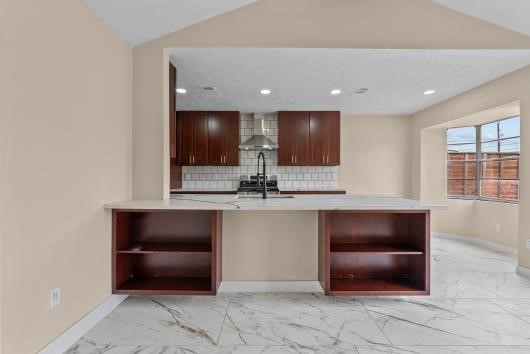 This photo showcases and open concept design, living and kitchen combination. custom built in shelves enhances living area