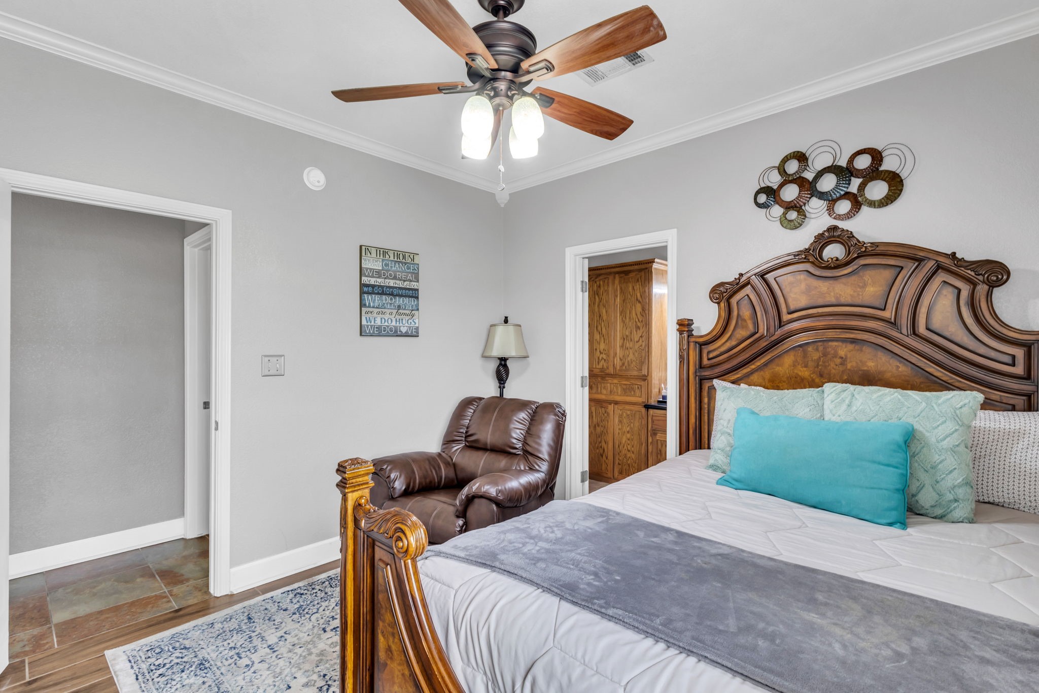 Guest bedroom #1 offers a comfortable layout with neutral wall colors, crown molding, a ceiling fan, and wood-look flooring. Includes convenient access to the adjoining bathroom.