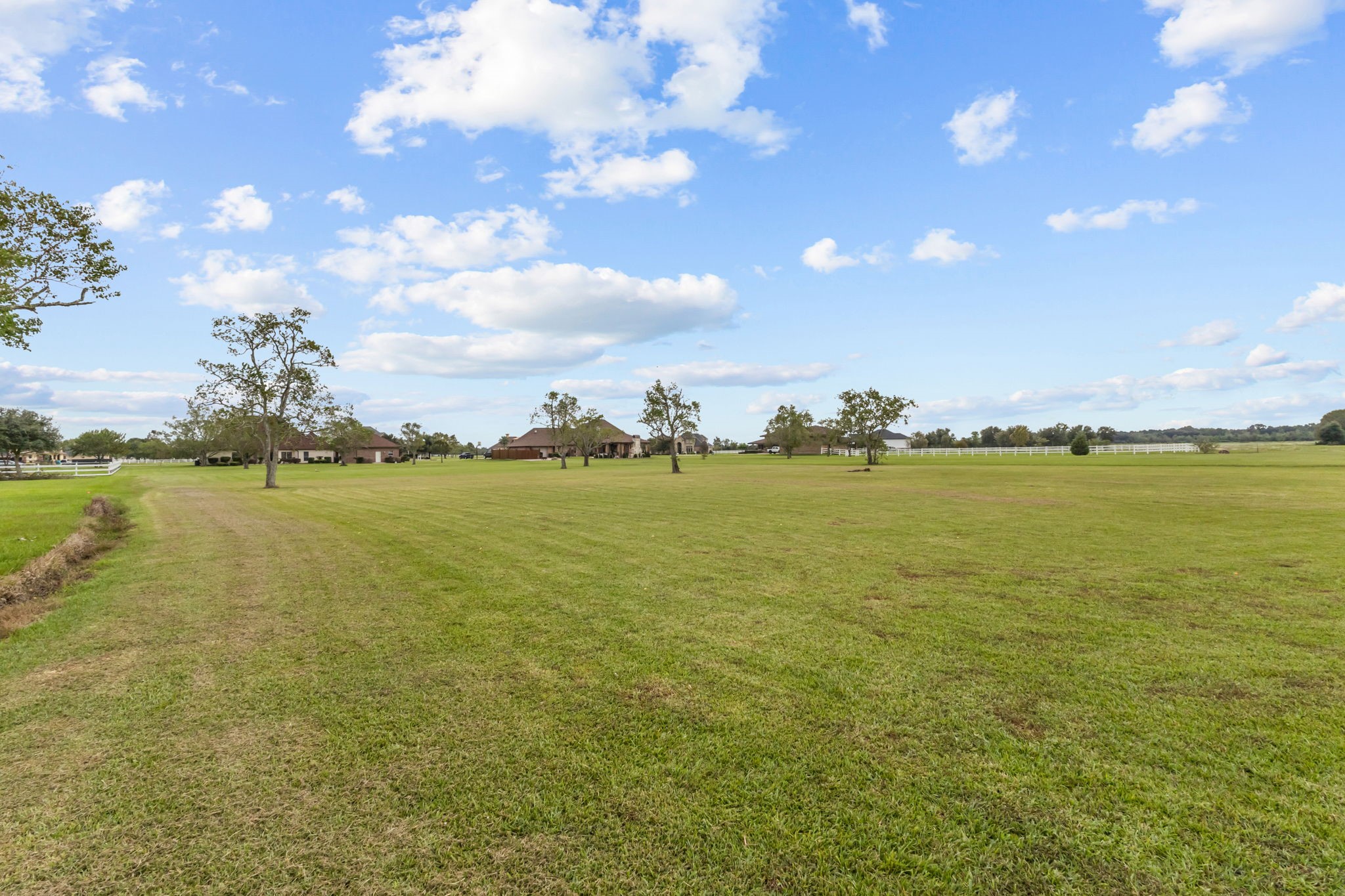 Another beautiful view of the expansive 2+ acre property, featuring wide open green space, scattered mature trees, and scenic surroundings. Plenty of room to enjoy outdoor activities, entertain, or bring your backyard vision to life.