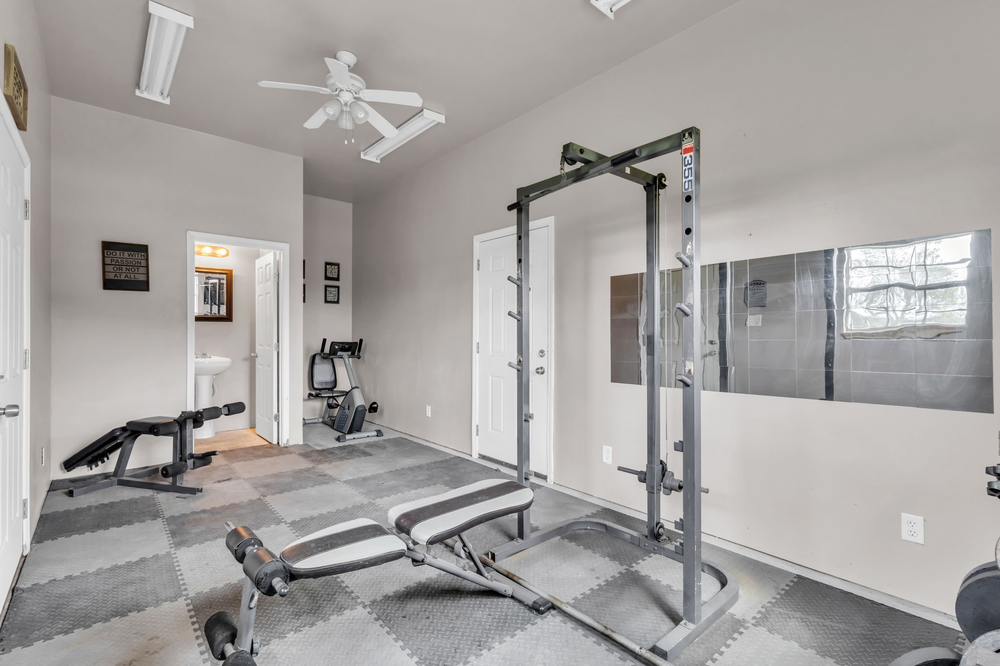 Additional flexible space located inside the detached garage, currently used as a private home gym. Features a convenient half bath, ceiling fan, and dedicated space for a potential shower addition. Ideal for a fitness room, hobby space, or home office.