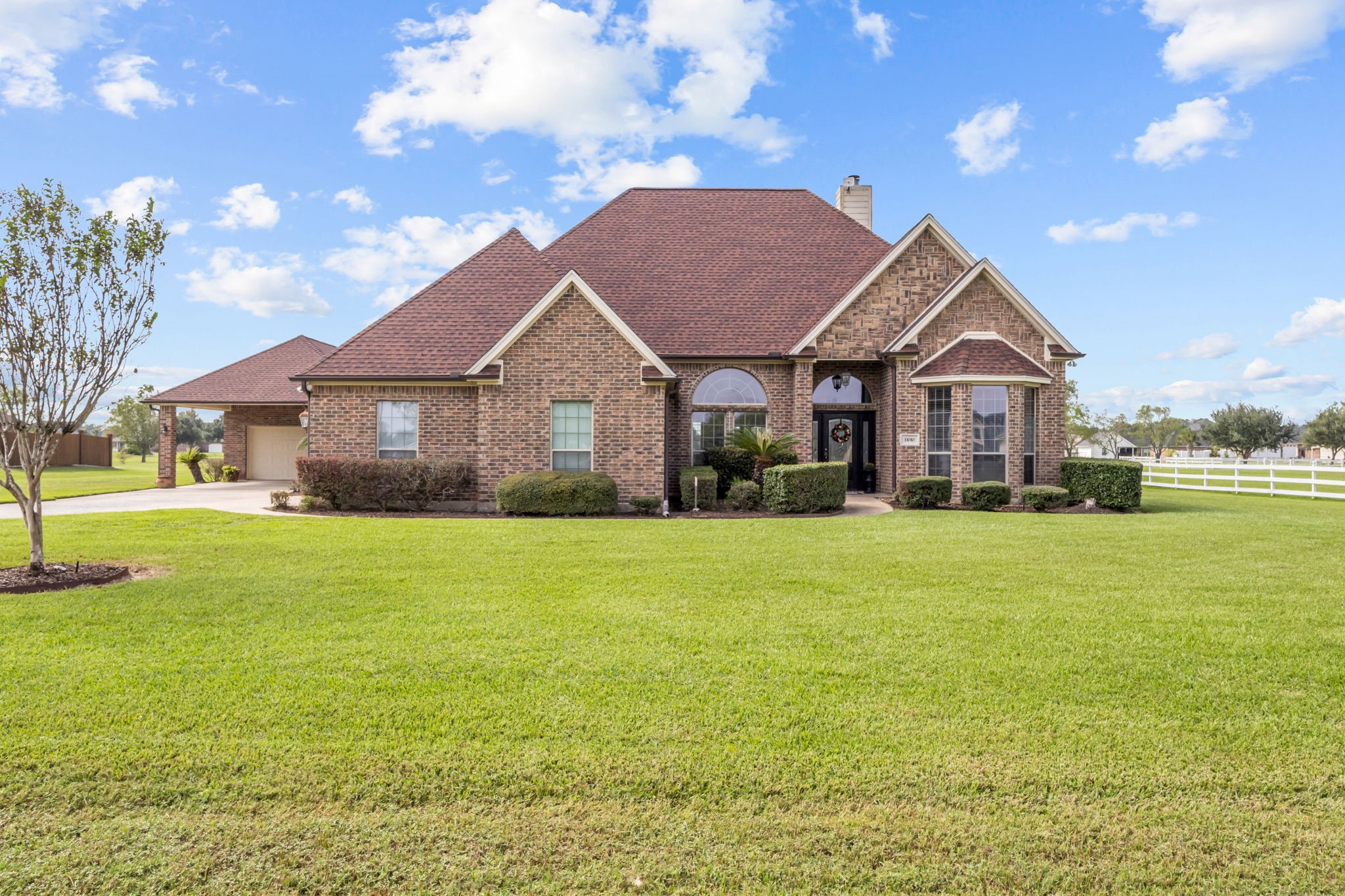 Beautiful brick home featuring impressive architectural details, a welcoming covered entry, and a spacious, well-maintained front lawn. Mature landscaping, an extended driveway, and a detached garage enhance the property's curb appeal.