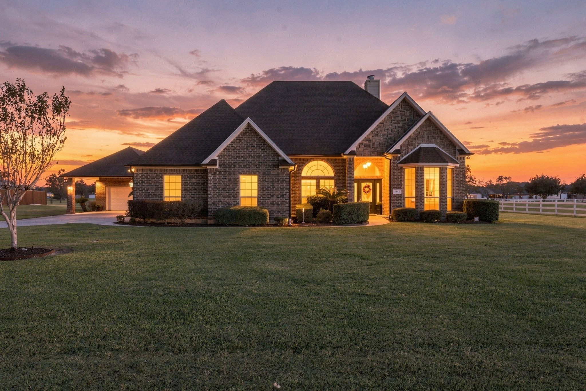 Stunning twilight view showing this beautiful brick home's elegant details, inviting illuminated entryway, manicured landscaping and expansive front lawn. Stunning twilight view showing this beautiful brick home's elegant details, inviting illuminated entryway, manicured landscaping and expansive front lawn.