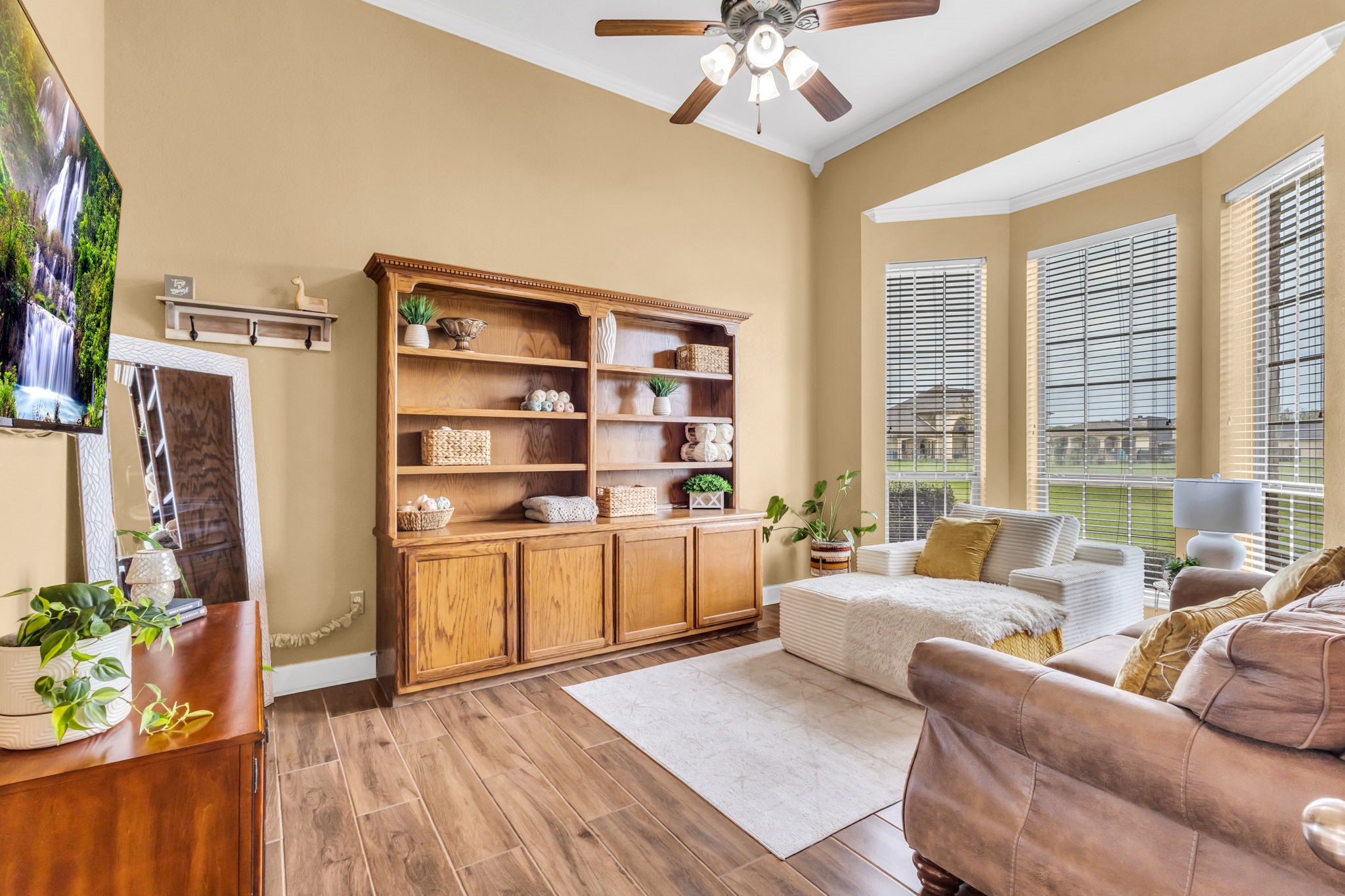 Spacious study featuring high ceilings, wood-look tile flooring, and a beautiful bay window that brings in plenty of natural light. A comfortable space for a home office or quiet retreat.