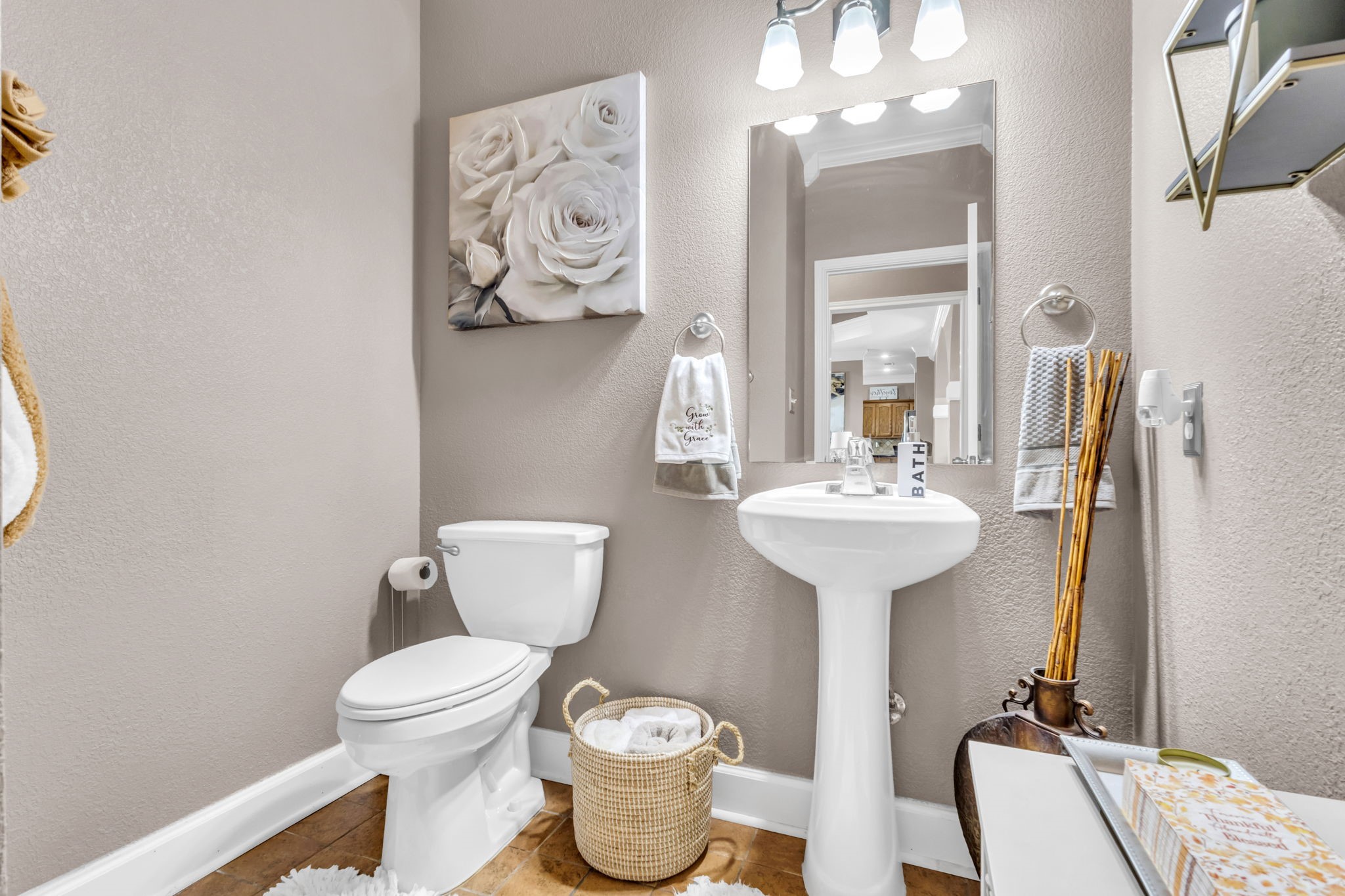 Convenient half bath featuring a pedestal sink, updated light fixture, neutral finishes, and tile flooring. A welcoming space for guests.