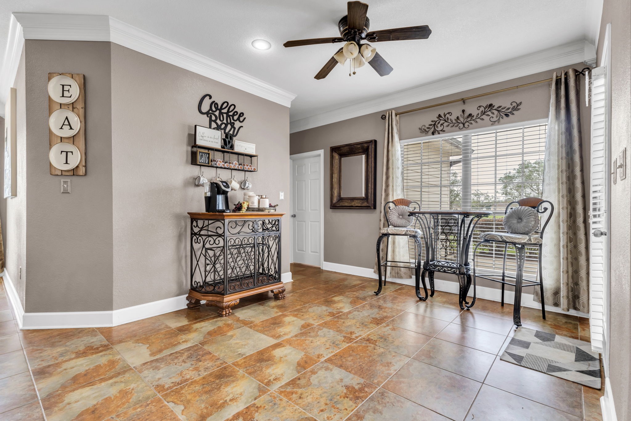 Versatile space currently used as a cozy coffee bar and sitting area, featuring a large window, tile flooring, and plenty of natural light. A great spot to enjoy your morning coffee or relax throughout the day.