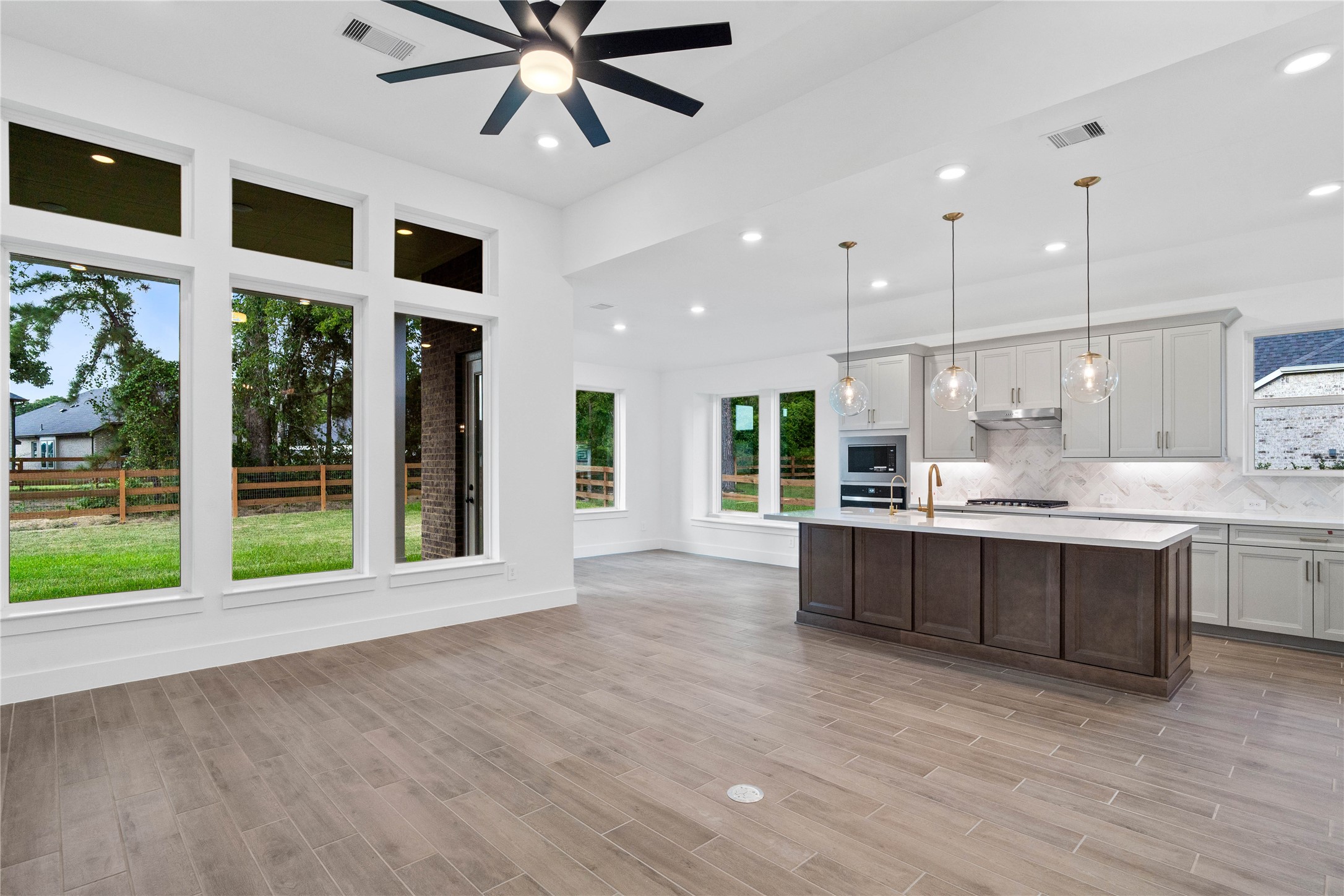 Bright, open-concept living designed for both everyday comfort and effortless entertaining. This expansive space features soaring ceilings, abundant natural light, and seamless flow between the kitchen, dining, and living areas.