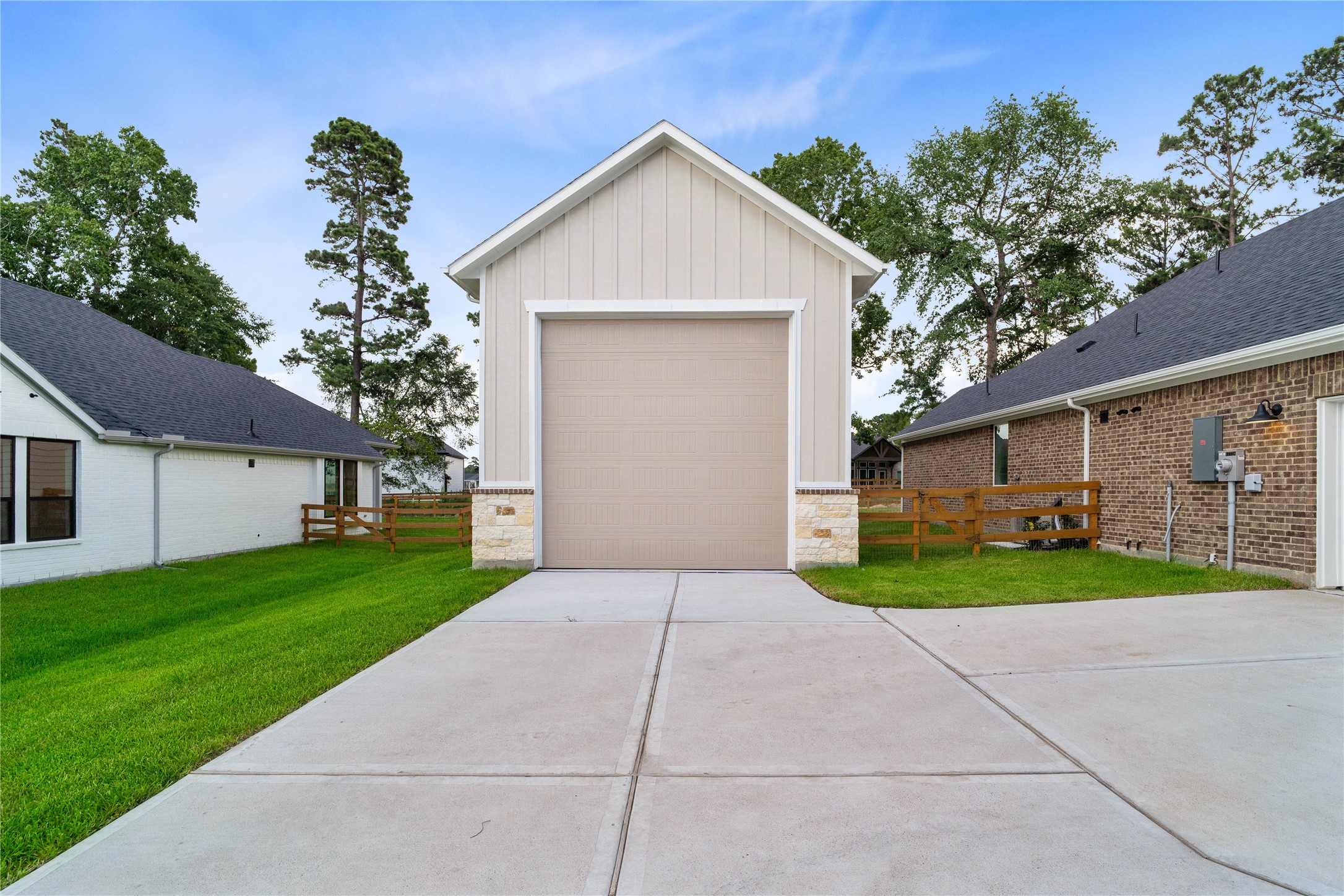 An impressive detached, oversized garage features a massive high-clearance bay door, offering the ultimate flexible space for RV parking, boat storage, or a professional-grade workshop.