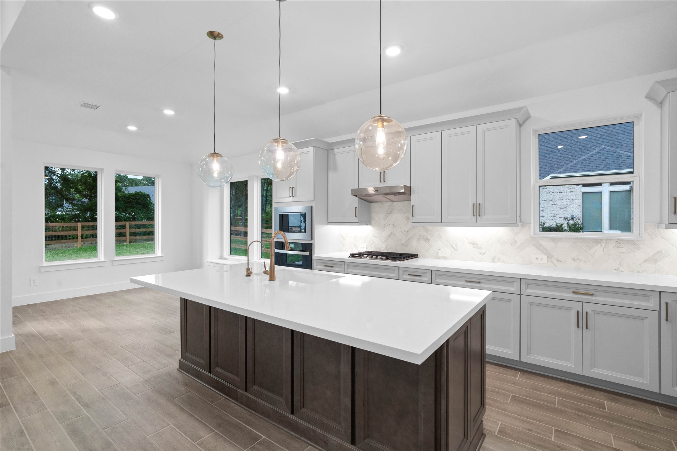 An expansive quartz island anchors the heart of the kitchen, showcasing a premium extended bar top that creates the ultimate hub for entertaining guests or enjoying casual conversation.