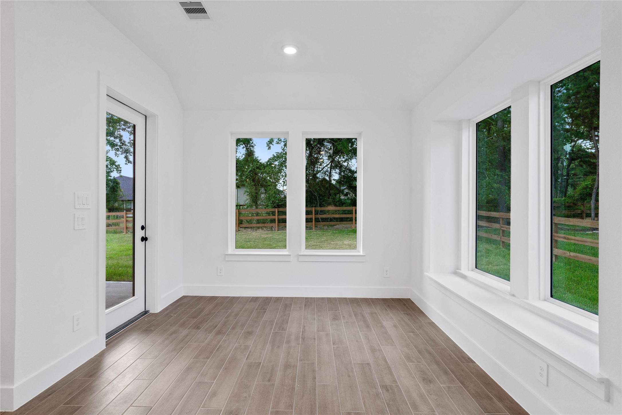 Create lasting memories around the table with family and friends in the dining! It showcases sloped ceilings, large windows, window seat, wood tile flooring, and recessed lighting for a warm and welcoming atmosphere. An access door to the back covered patio and backyard is strategically placed to create a seamless indoor-to-outdoor living space, making it perfect for entertaining.