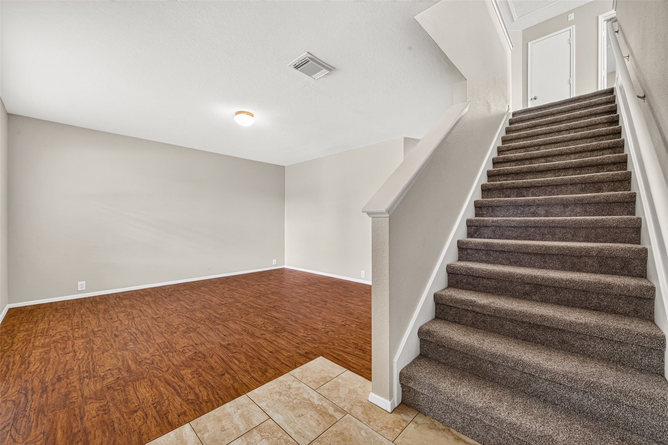 Entrance view of the home showcasing the staircase and the spacious formal living room