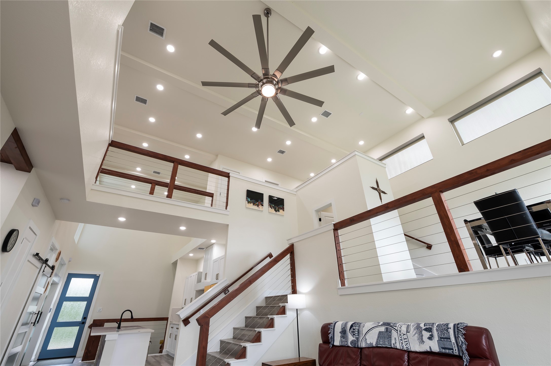 Sherwin Williams Swiss Coffee neutral paint tones throughout with 100% LED lighting; upscale ceiling fan and coated horizontal cable stairway and catwalk with cedar railing.