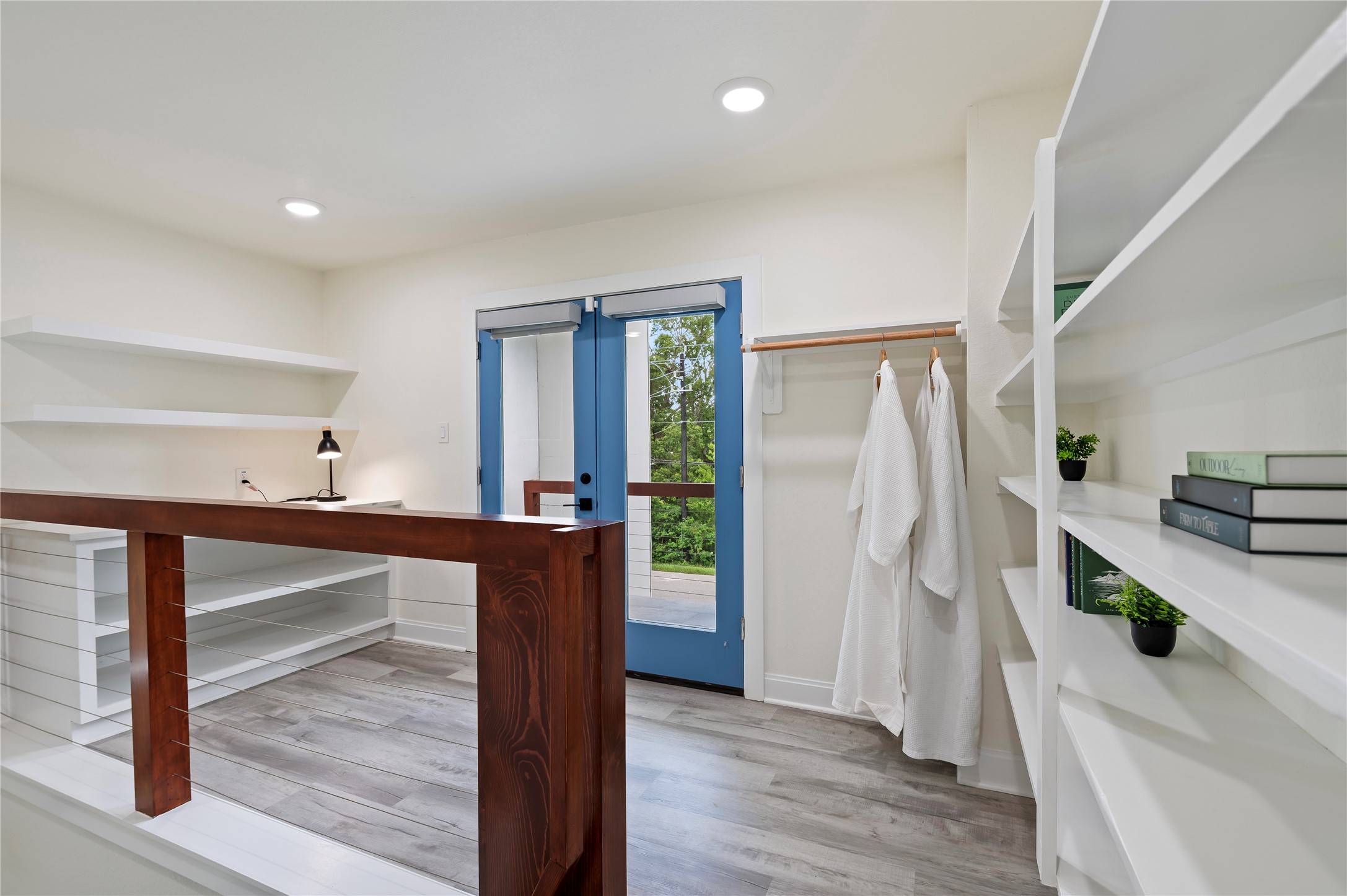 Modern style upstairs loft library area storage shelves and private covered balcony overlooking the property.