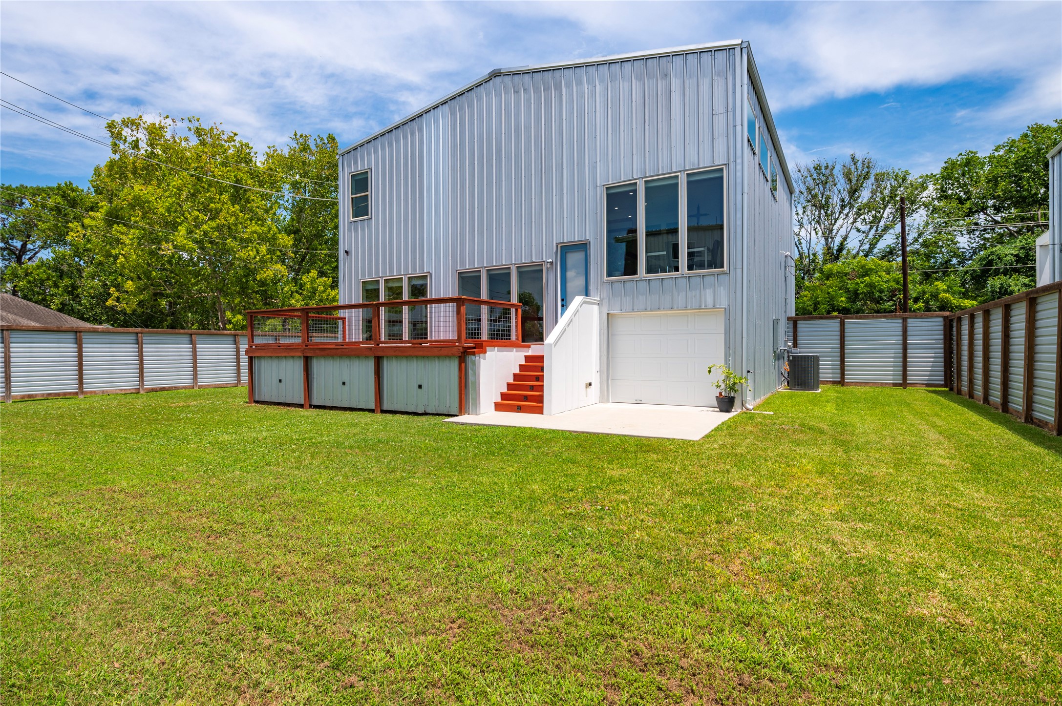 Back of the home with garage door and cement deck.