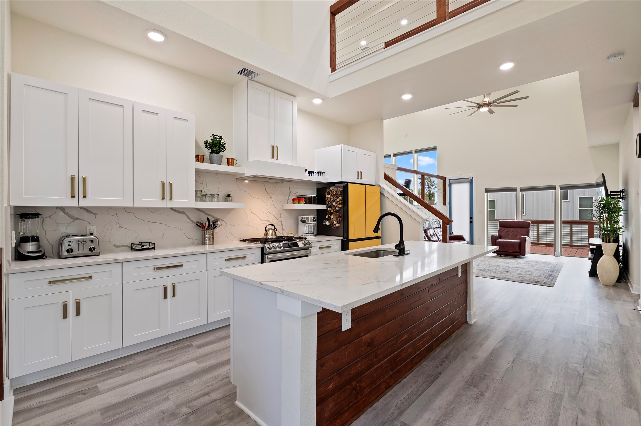 Stunning island kitchen with White Quartz countertops and cedar plank accent wall. Updated Samsung Bespoke Dishwasher, Range, and Refrigerator.