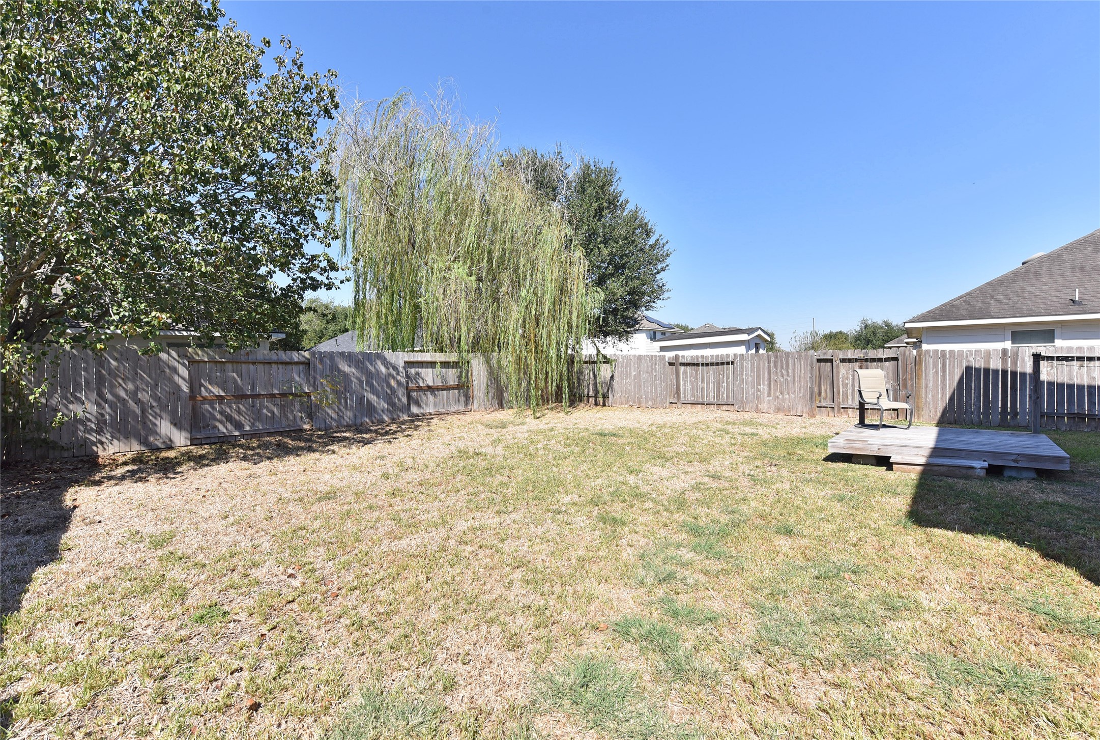 Large yard with a raised deck.