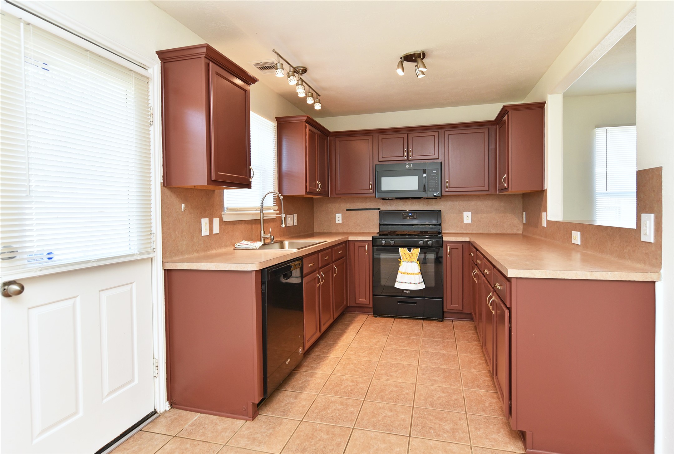 This kitchen features a just installed microwave, oversized kitchen sink and faucet.