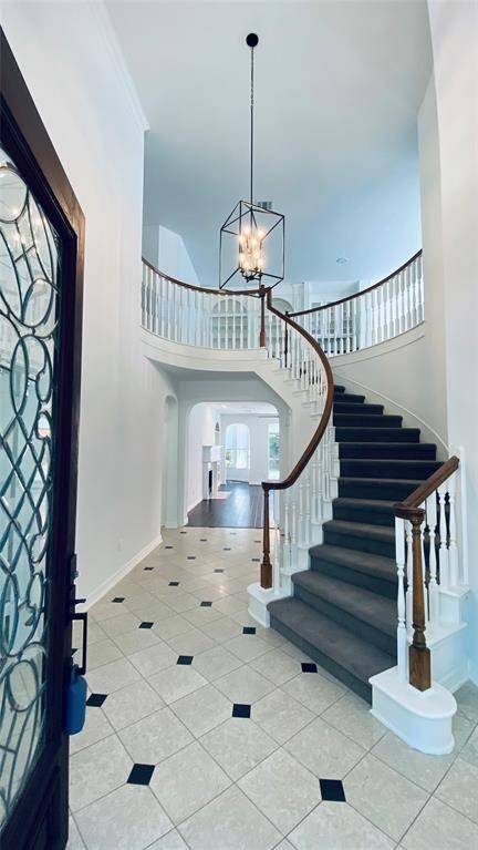 Elegant entryway featuring a grand staircase and stylish tile flooring, welcoming you home with sophistication.