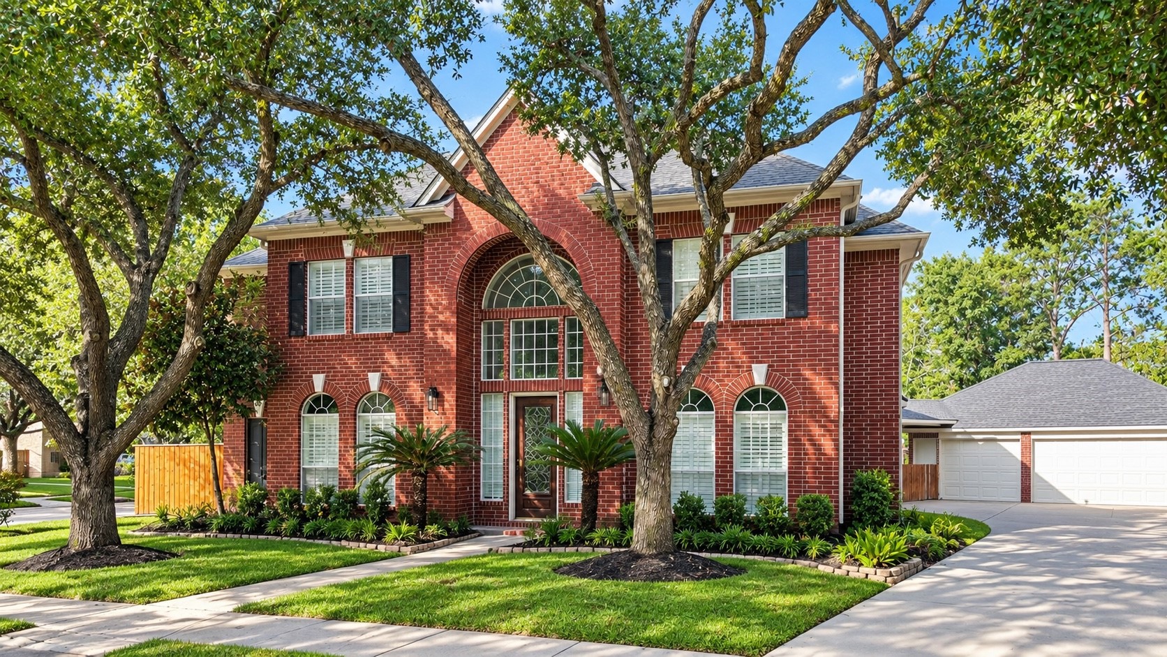 Charming elevation with lush, mature trees.
