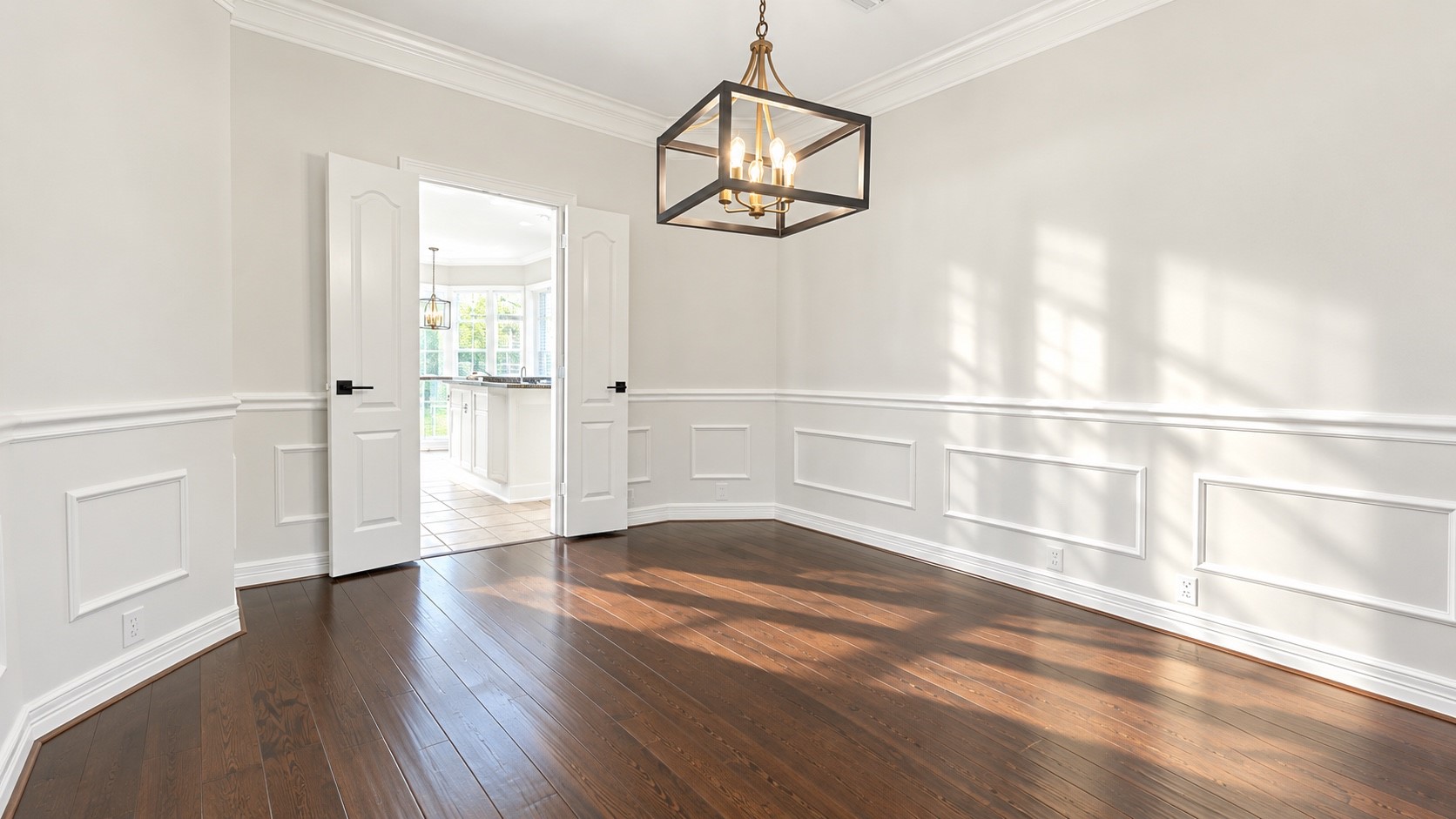 Elegant dining room featuring rich wood flooring and seamless kitchen access.