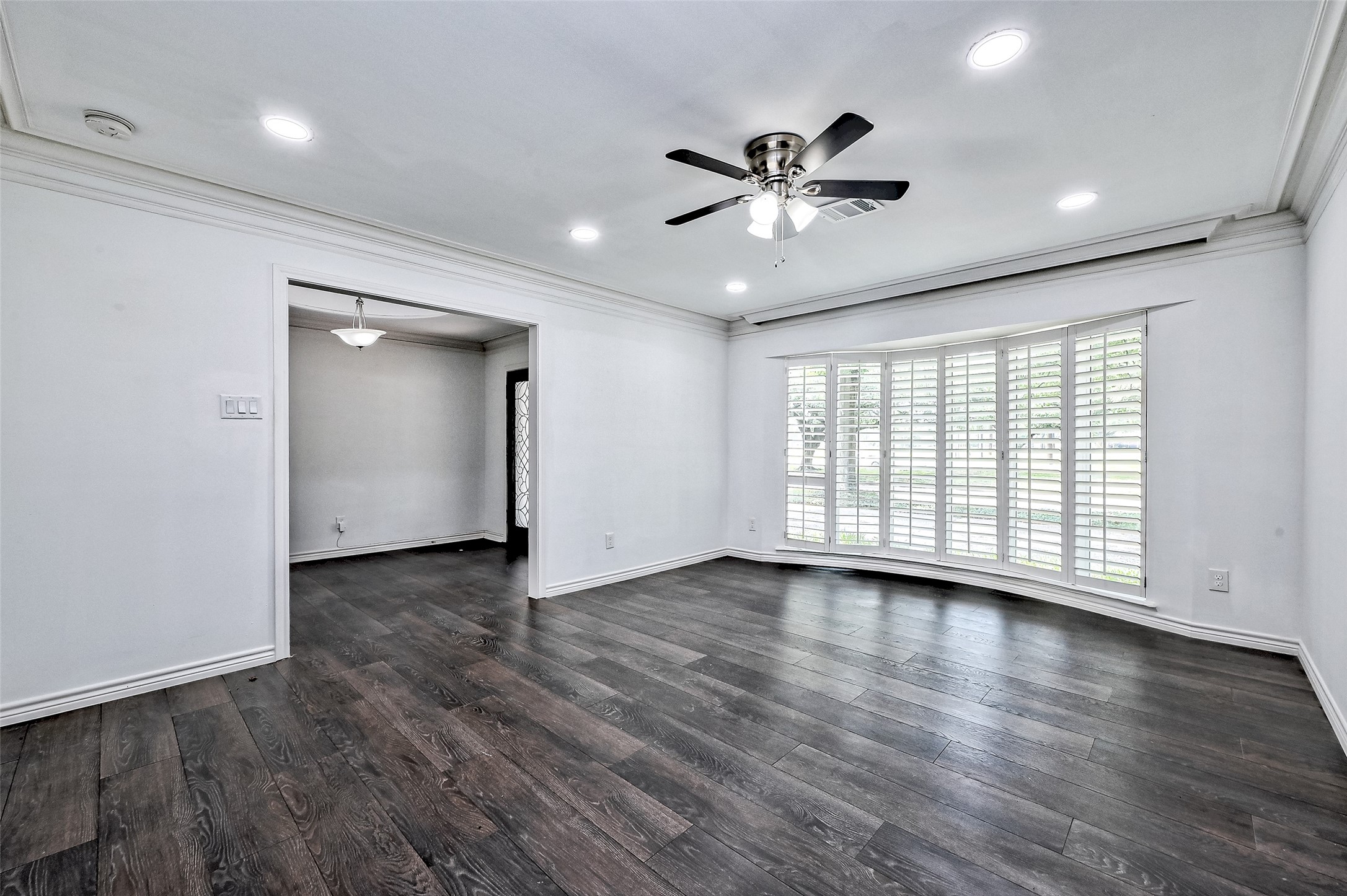 Living room is with ball window and ceiling fan, recess lights.
