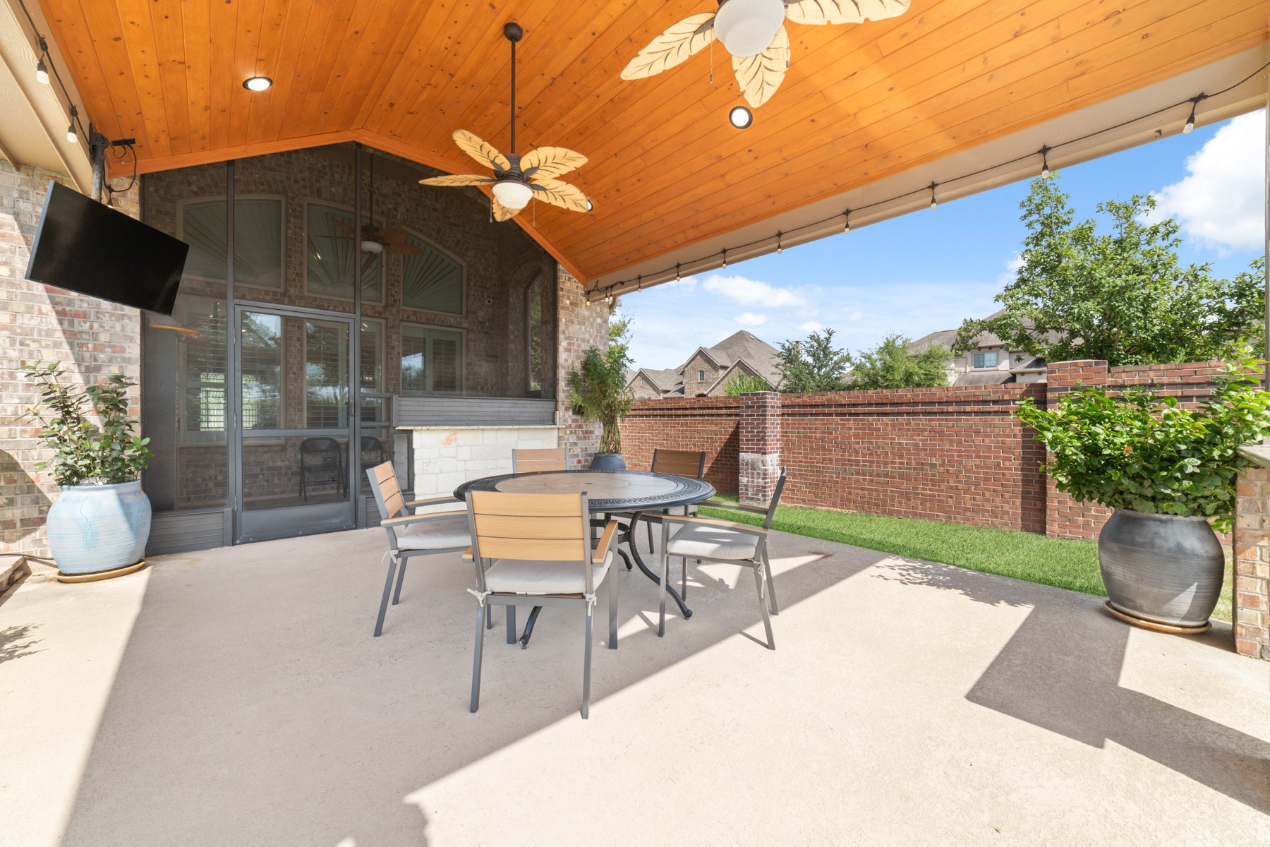Spacious covered patio with a stylish wood-paneled ceiling perfect for outdoor dining.