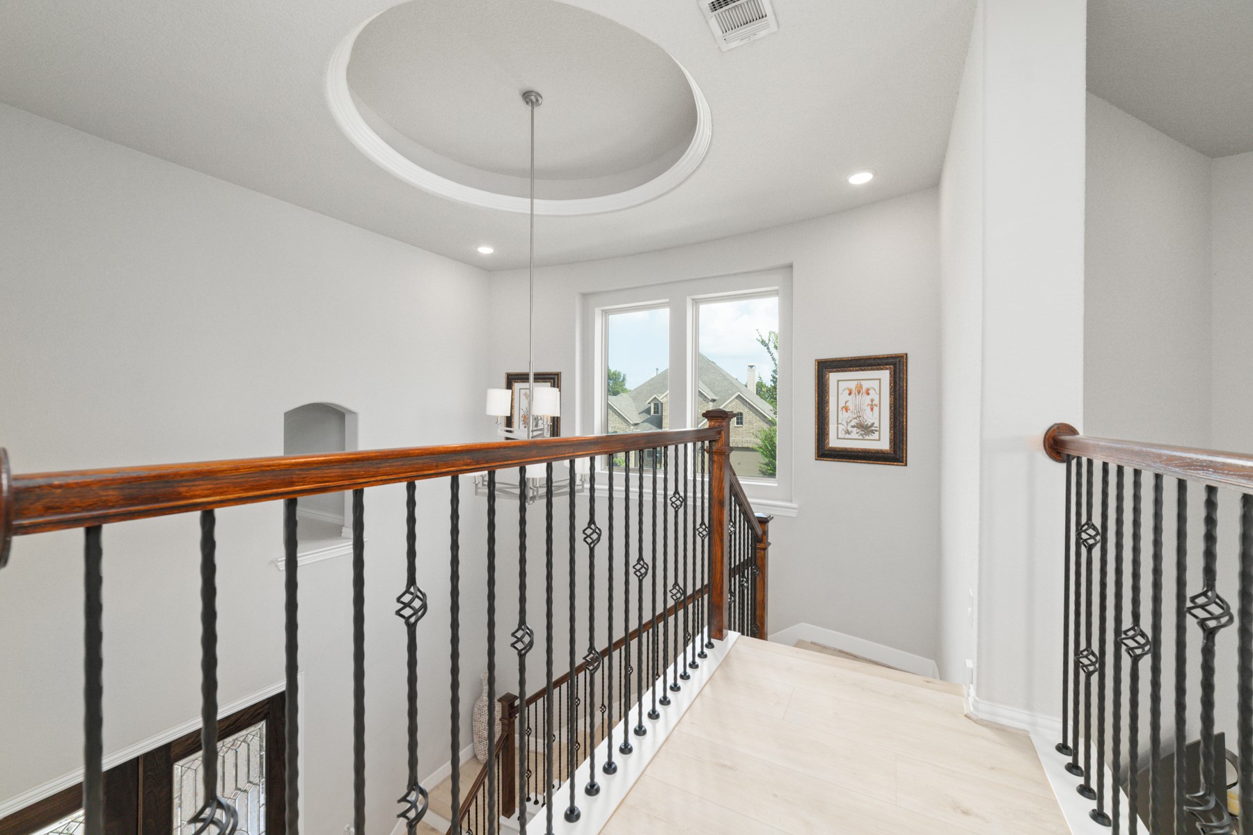 Elegant staircase landing featuring a stylish chandelier.