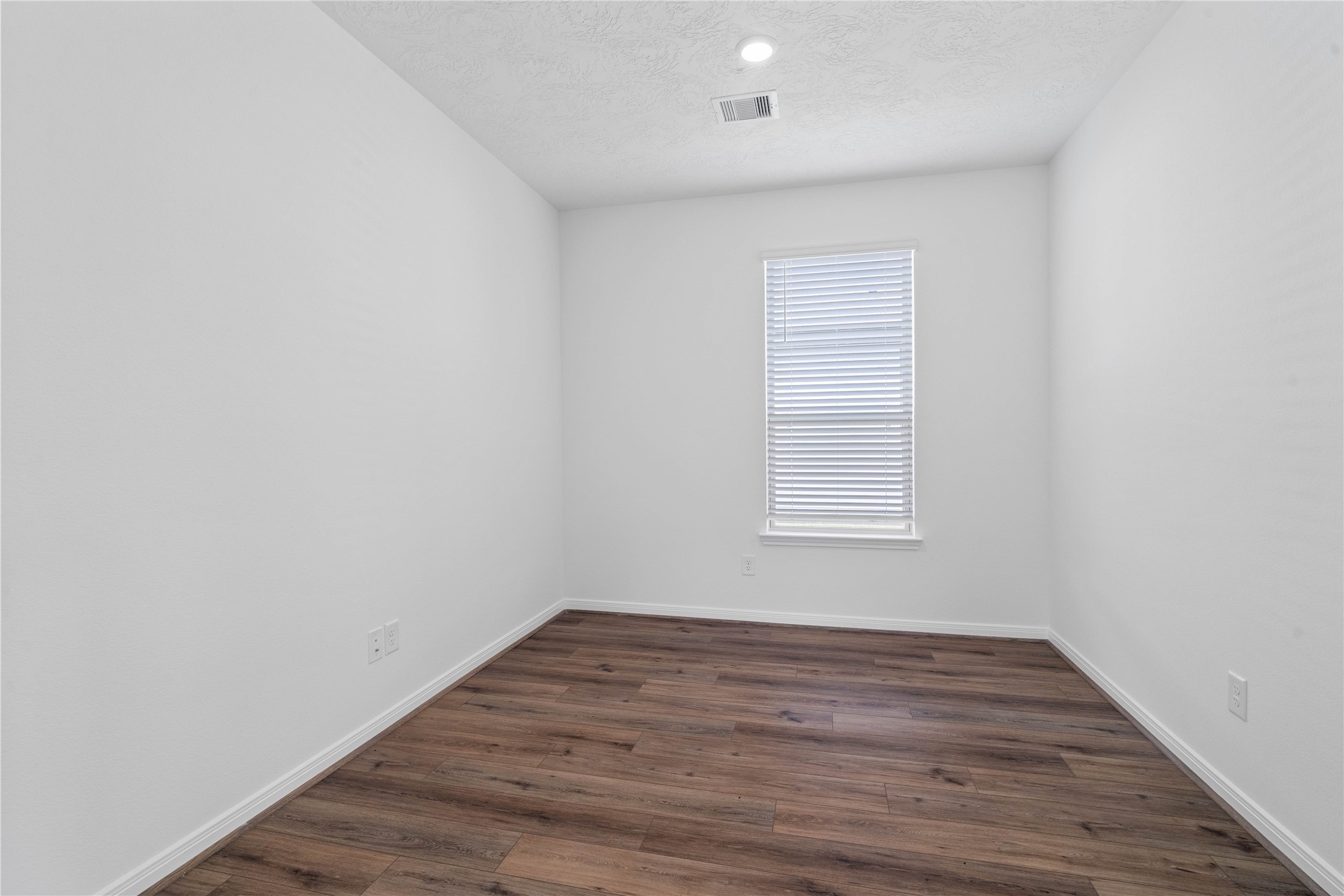 The Den is a versatile and additional living space that can be used as a home office, hobby or play room. It features durable vinyl plank flooring, high ceilings, recessed lighting, neutral paint, and a large window with blinds.