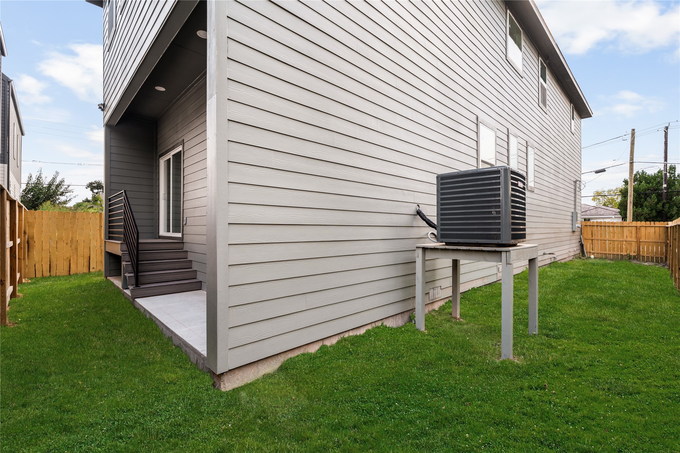 At the rear, a covered back porch steps down to the fenced backyard, where durable lap siding and open
green space leave room for play, pets, or a future garden.