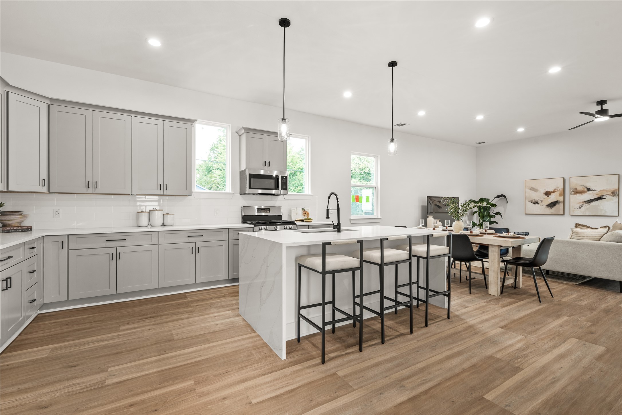 The kitchen's generous scale is on full display as the island extends toward the dining area and living room,
forming one continuous, light-filled space for everyday living and entertaining.