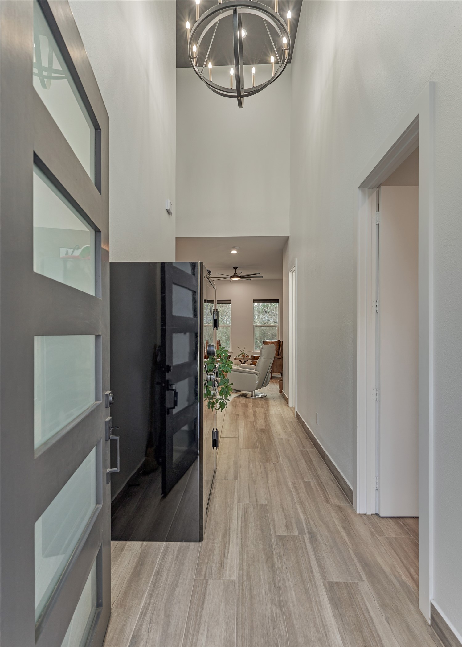 Step into a grand two-story foyer featuring statement lighting, soaring ceilings, neutral tones, and sleek, clean lines.