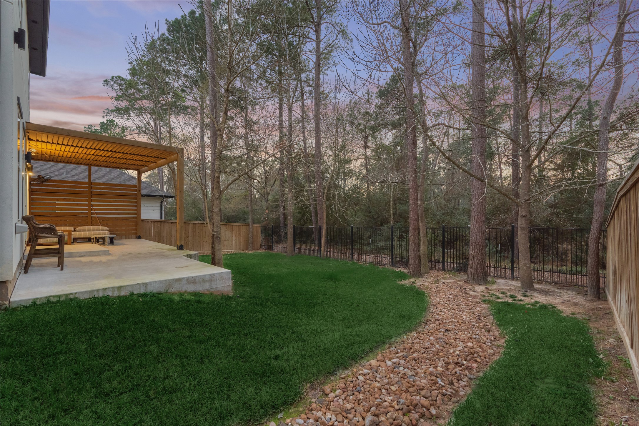 The wrought-iron fencing keeps views unobstructed, allowing you to fully enjoy nature and birdwatching in the spacious backyard and the serene wooded area beyond.