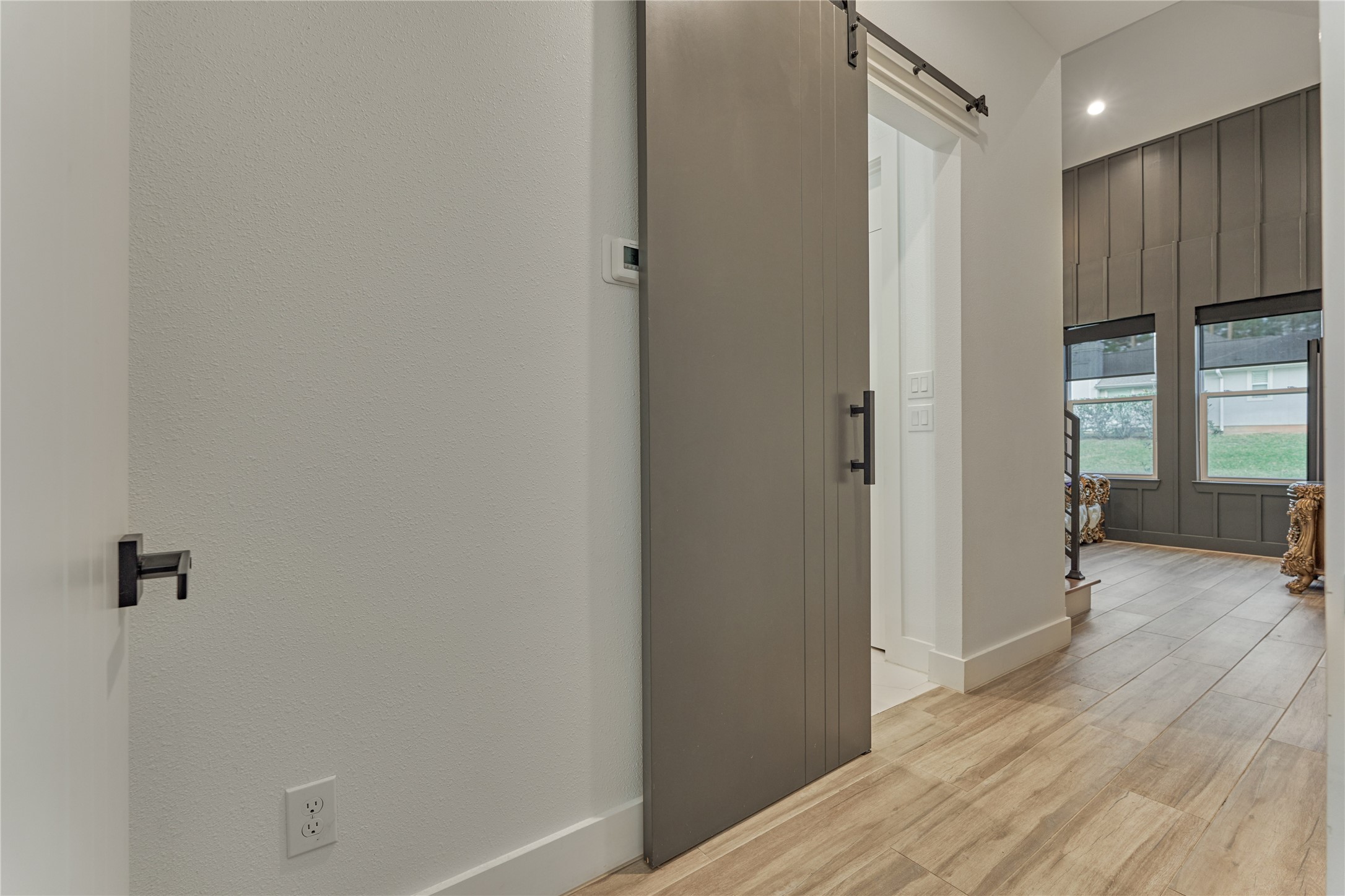 A private hallway leads to the owners retreat, featuring a stylish barn door entry into the ensuite bath